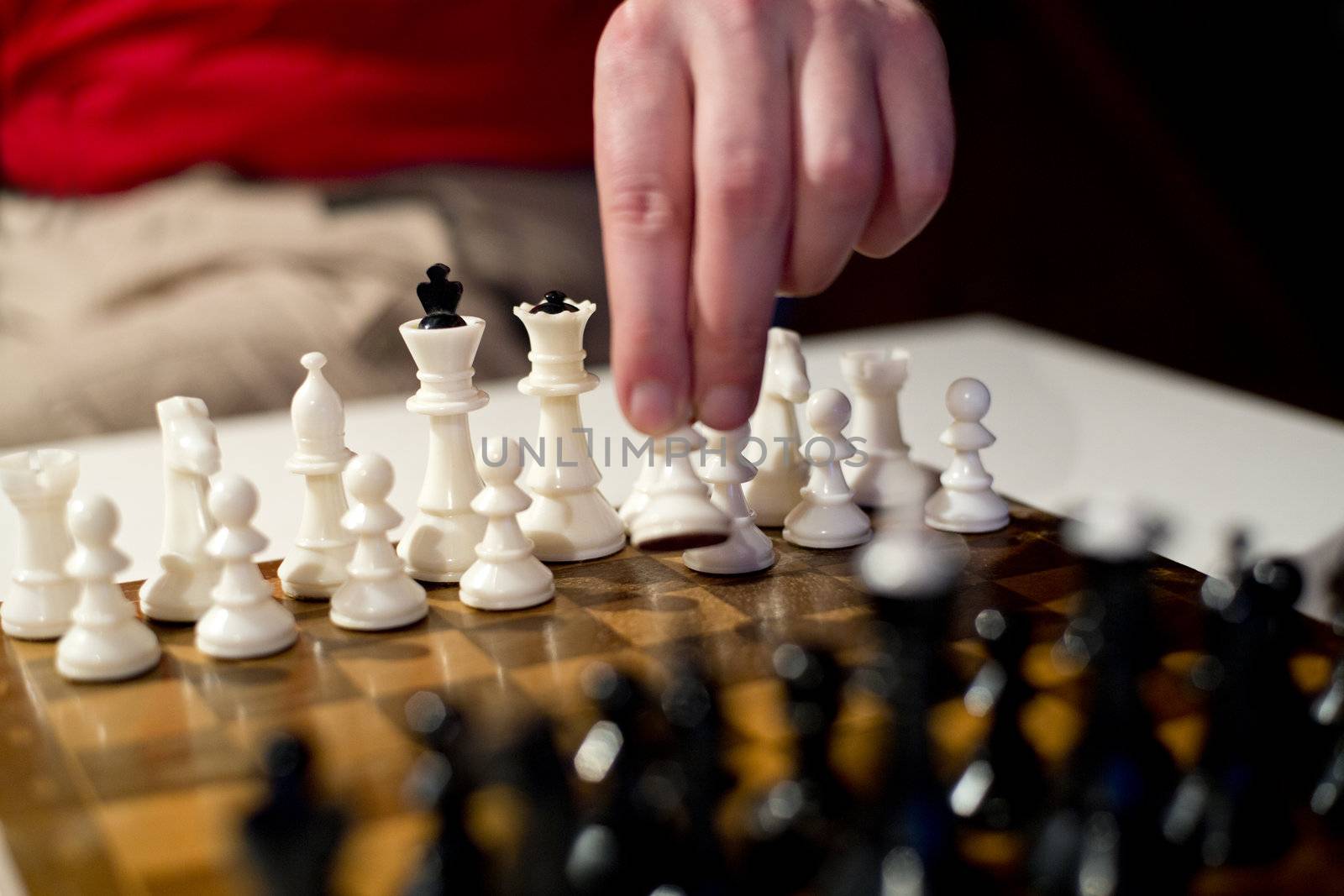 Chess board and white pawn in player hand
