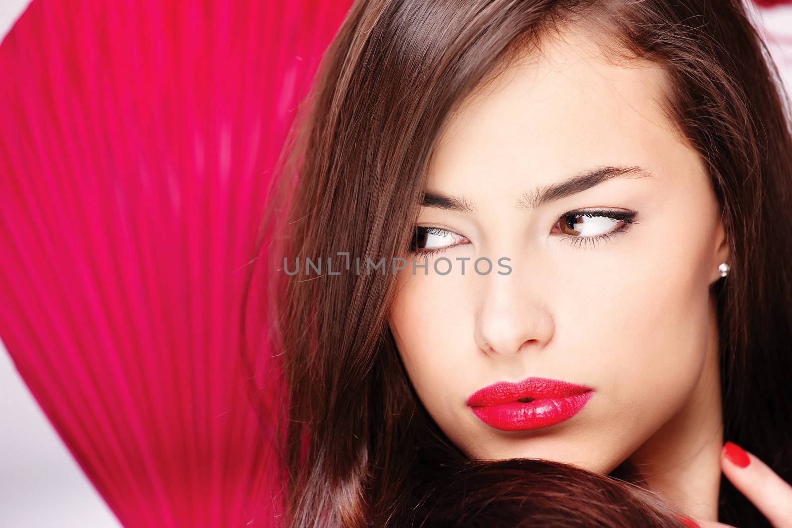 Pretty lady with big red lips in front of a red fan