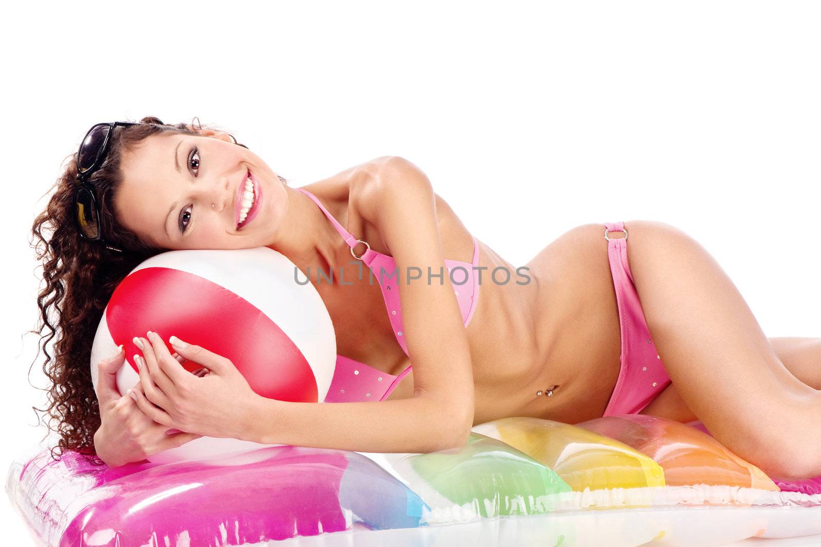 Smiled curl hair girl in bikini with ball laying on air mattress on white background