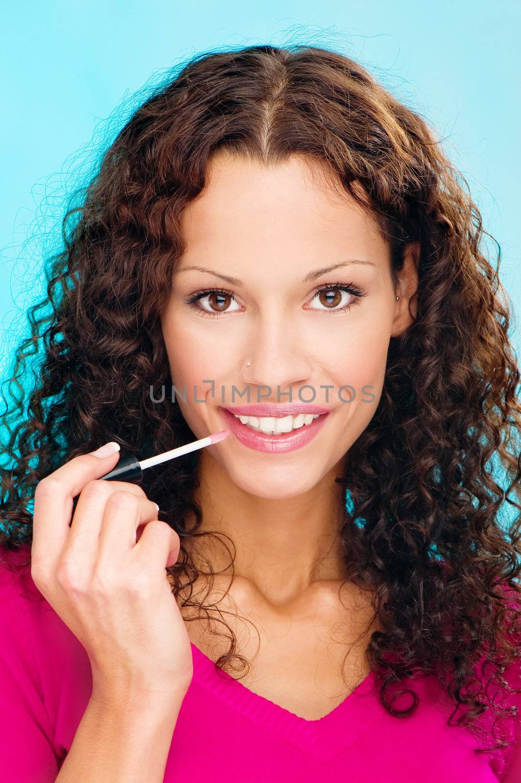 Pretty smiled woman putting lipstick on her lips