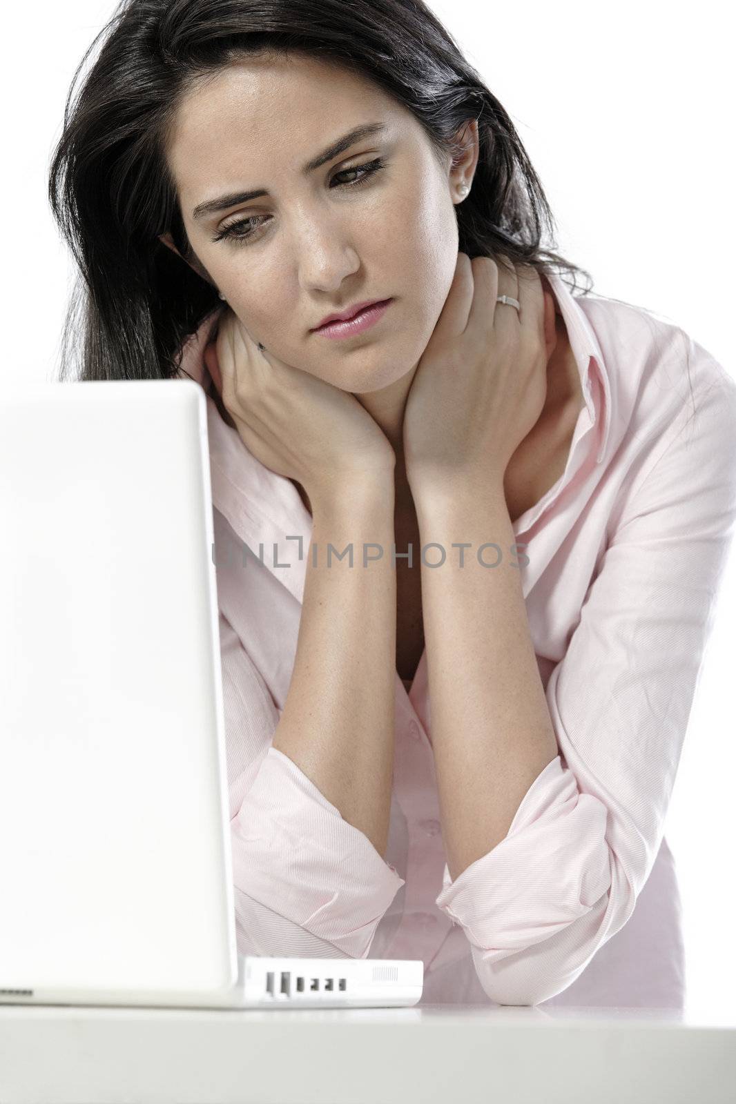 Beautiful young woman with neck pain at her office desk