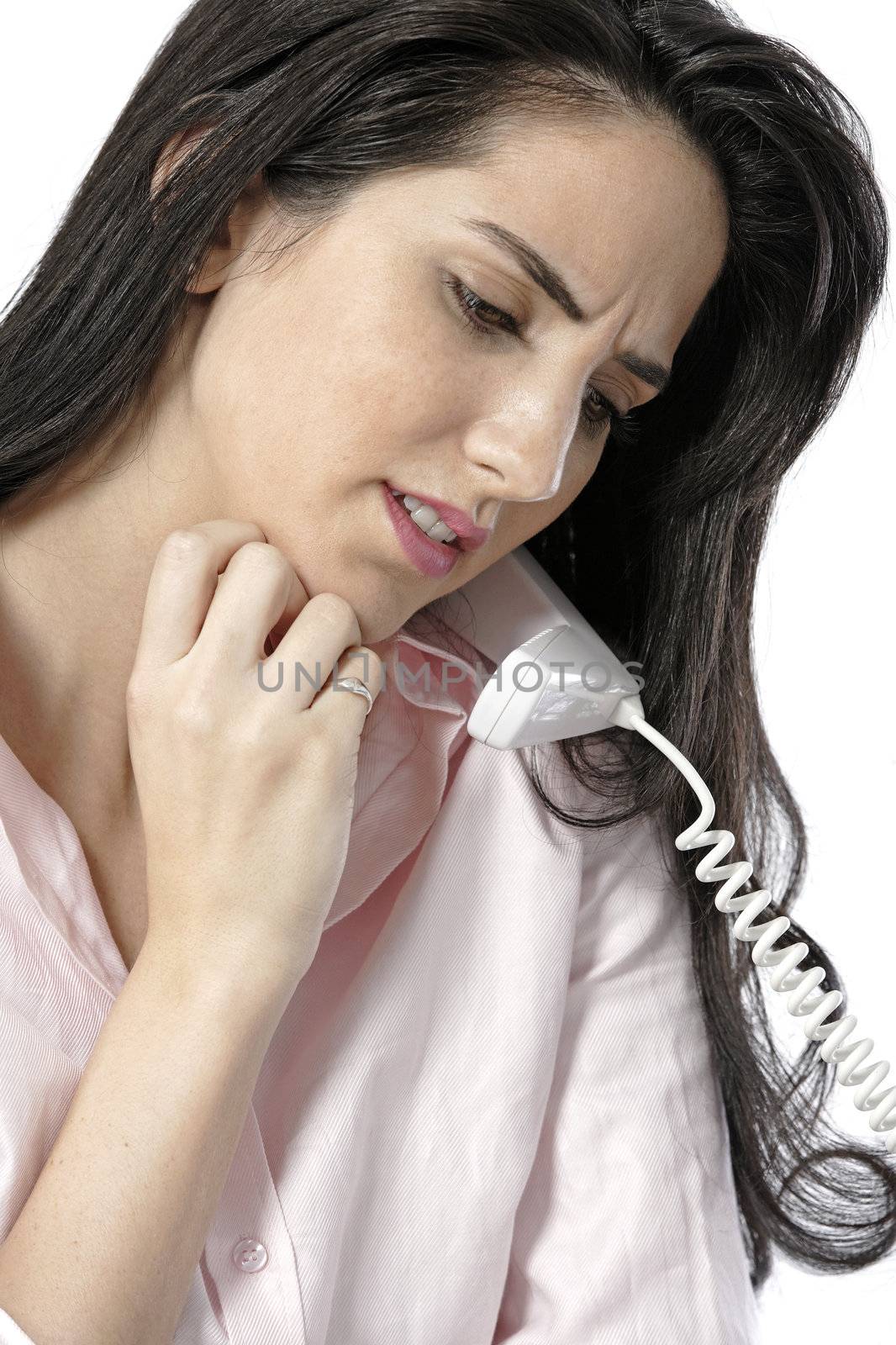 Beautiful young woman with neck pain at her office desk whilst on the phone