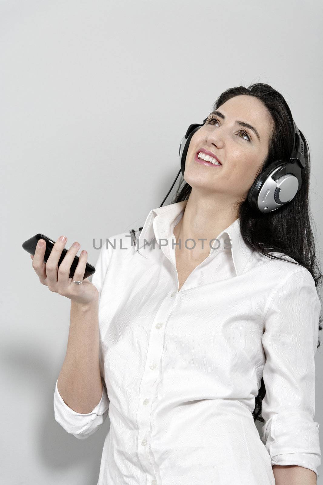 Woman listening to music on mobile phone by studiofi