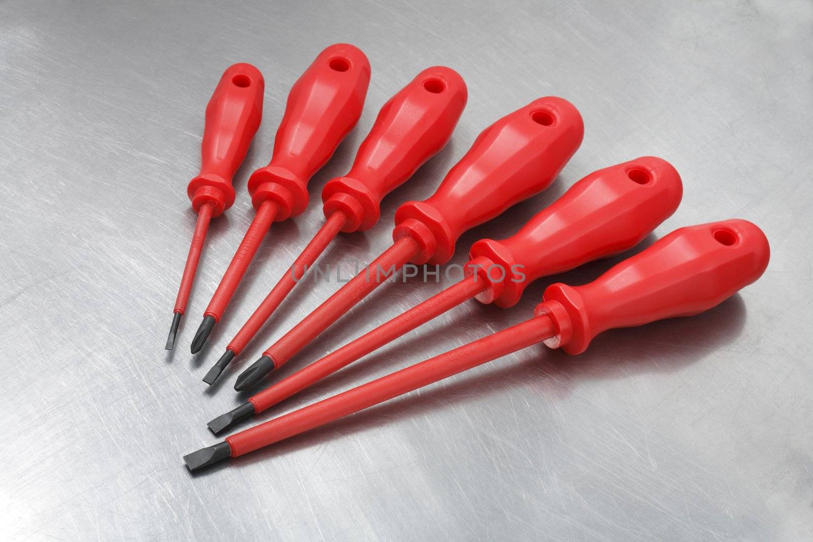 A Set of new electrician's insulated screwdrivers on scratched metal surface