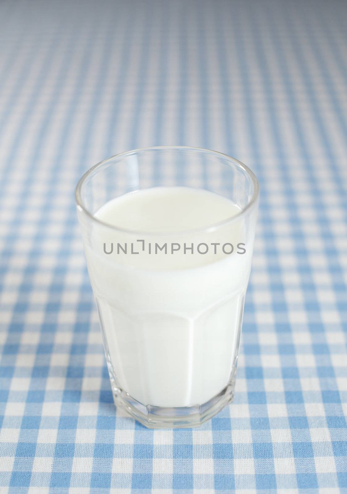 A glass of milk on plaid tablecloth
