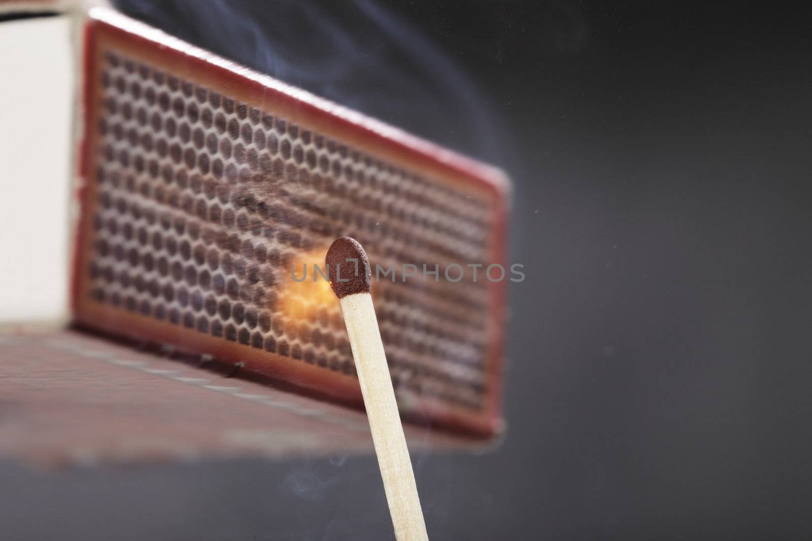 A Match ignited by rubbing the match head against a match box.