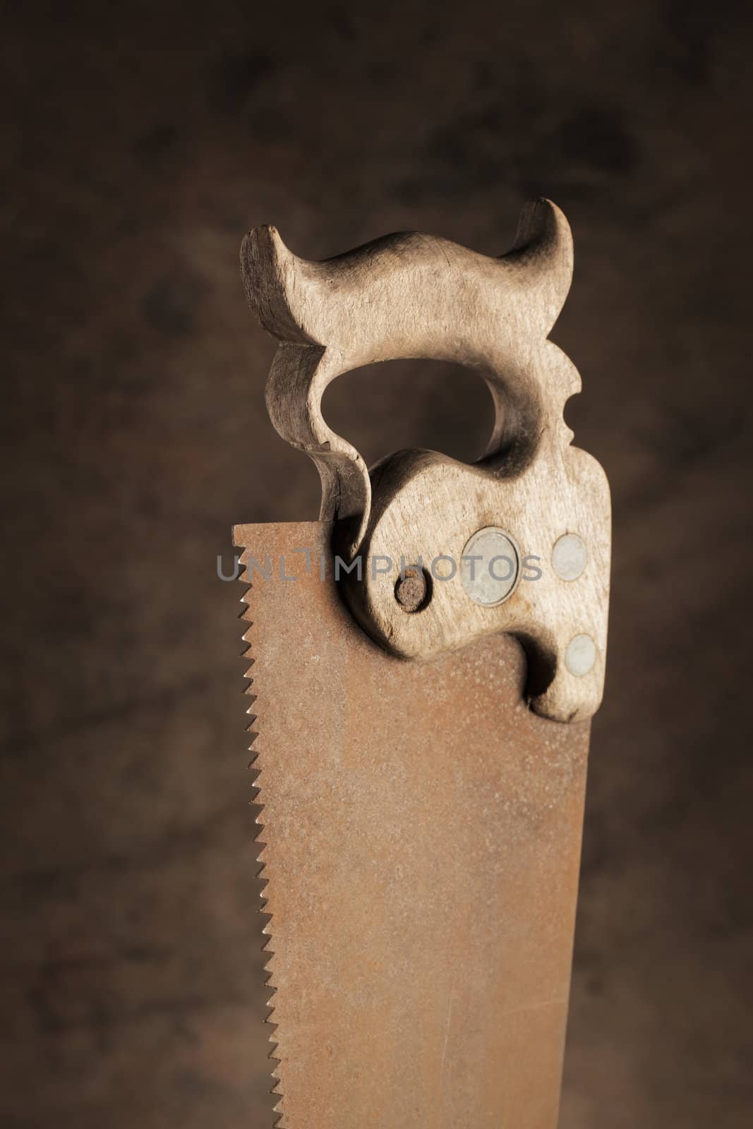 Wooden handle of an old rusty saw.