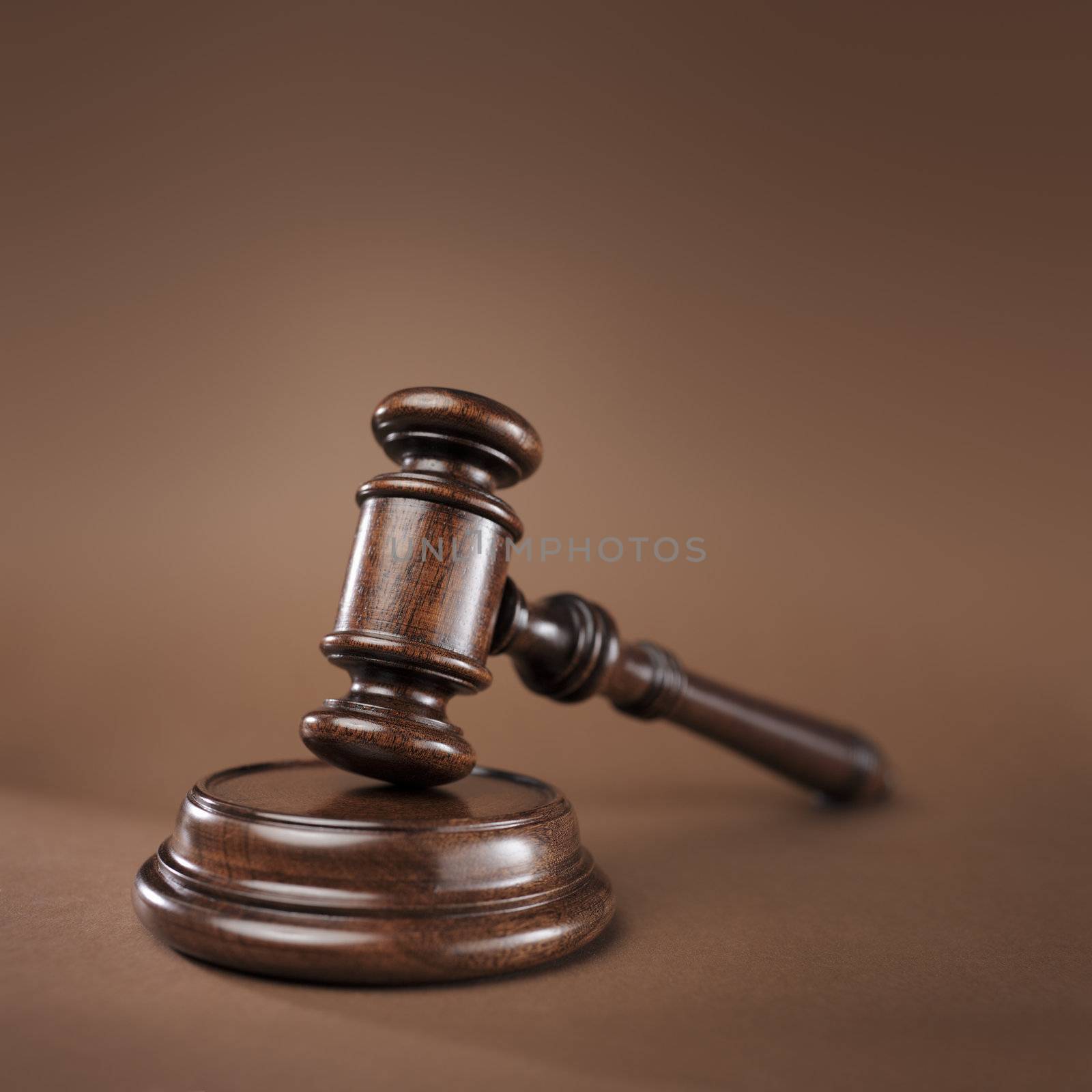 High quality wooden gavel and block on brown background. Short depth-of-field.