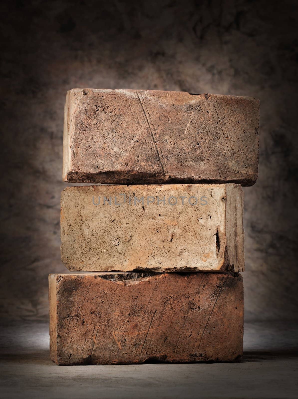 Three old used red clay bricks stacked.