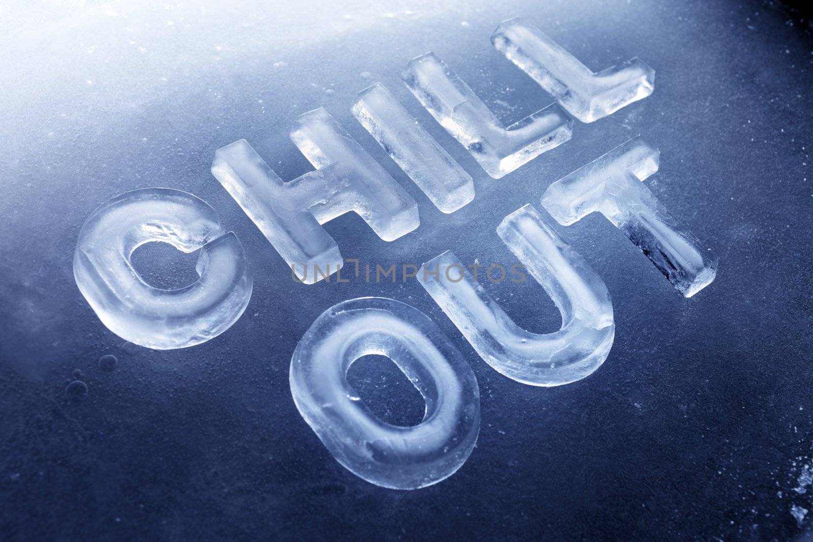 Words "Chill Out" made of real ice letters on ice background.