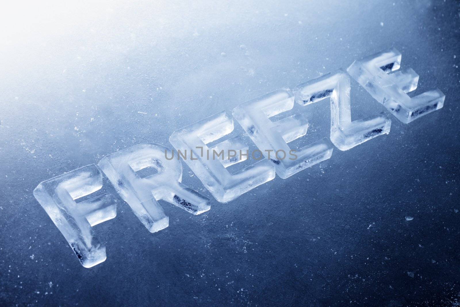 Word "Freeze" made of real ice letters on ice background.