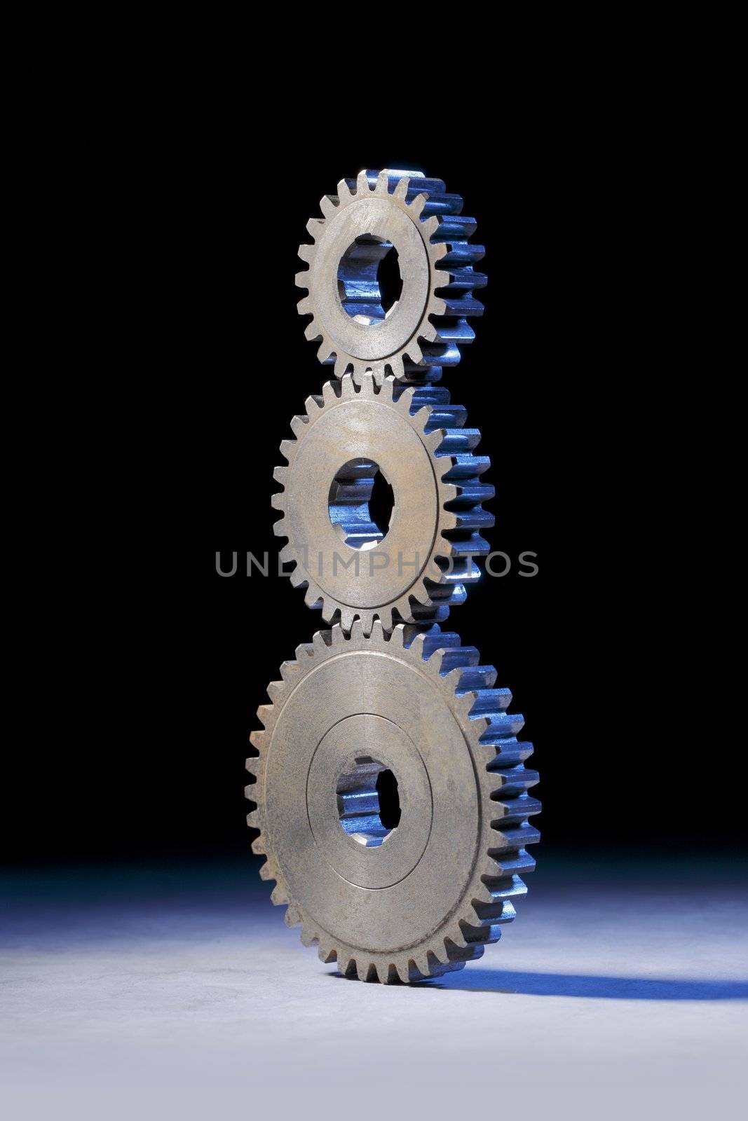 Still life with three cog gear wheels stacked on eachother.