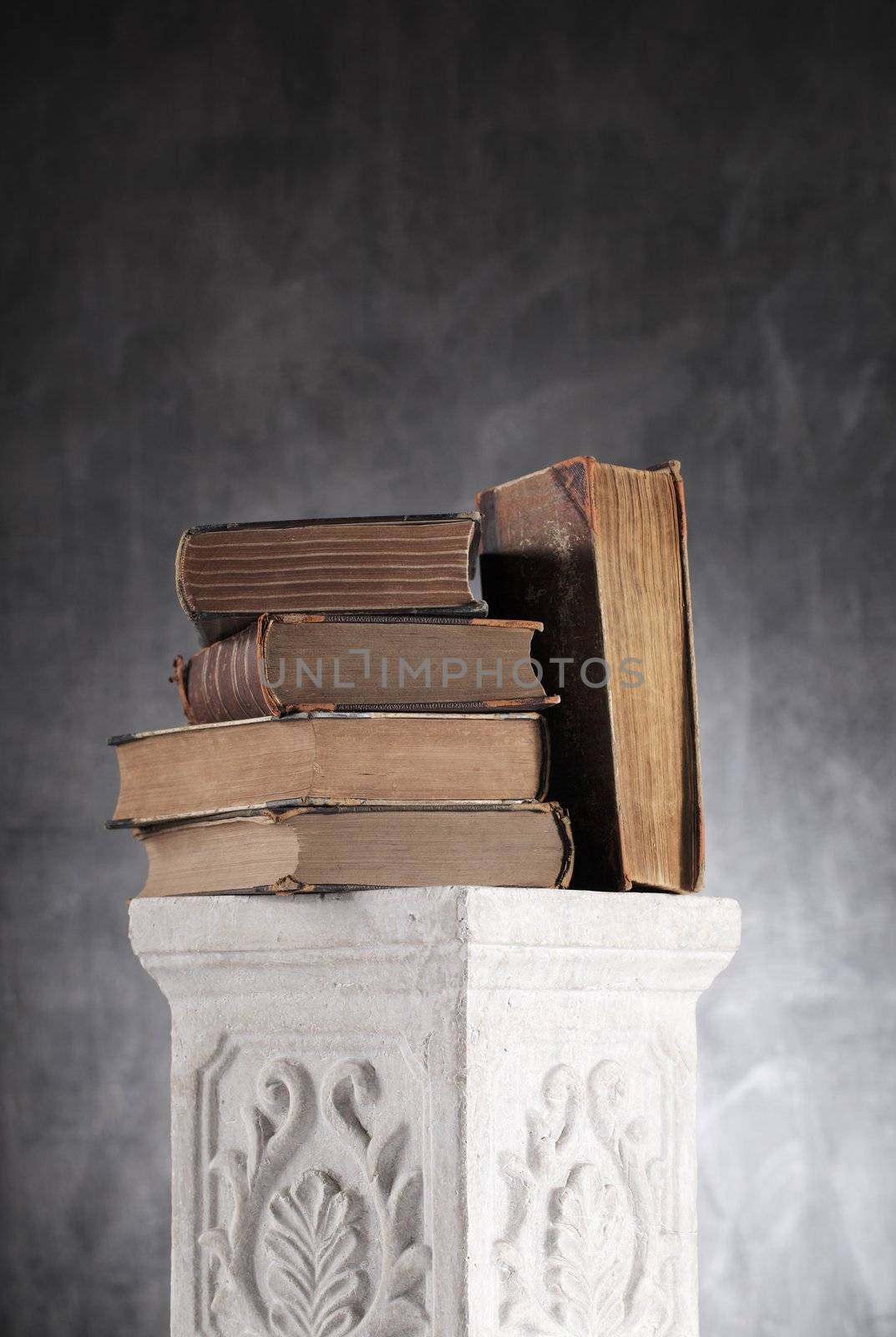 Old yellowed books on a plaster column.