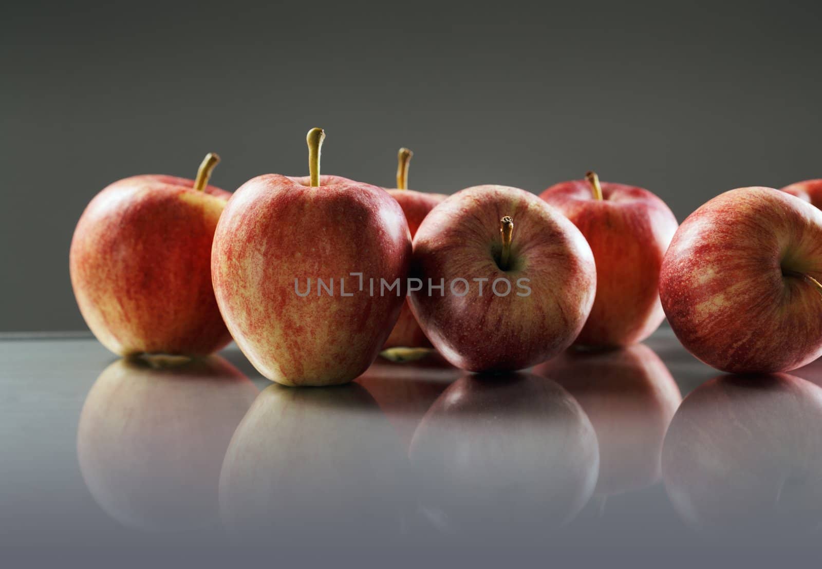 Red Apples on reflective surface.