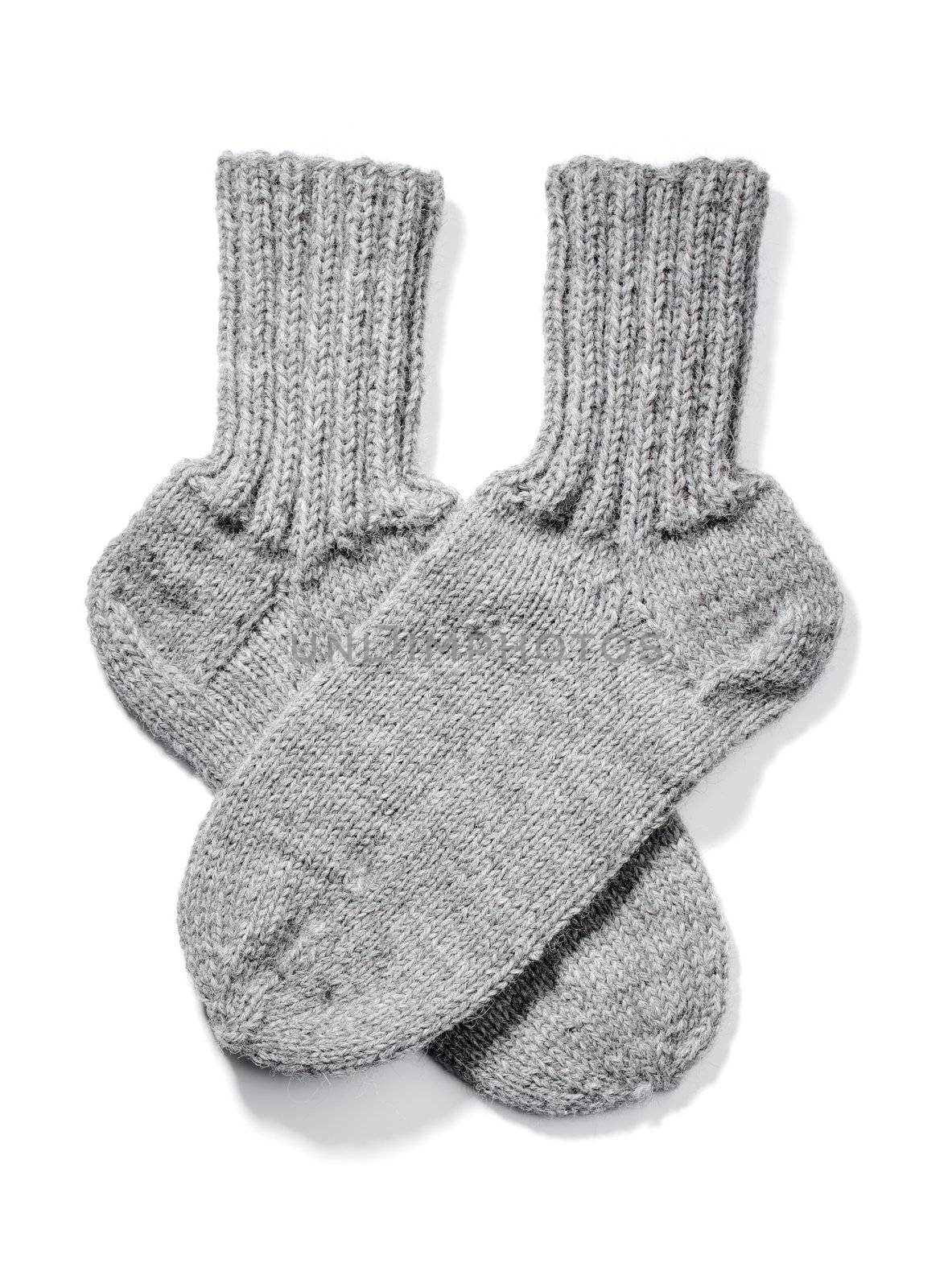 Hand-knitted warm wool socks isolated on white with natural shadows.