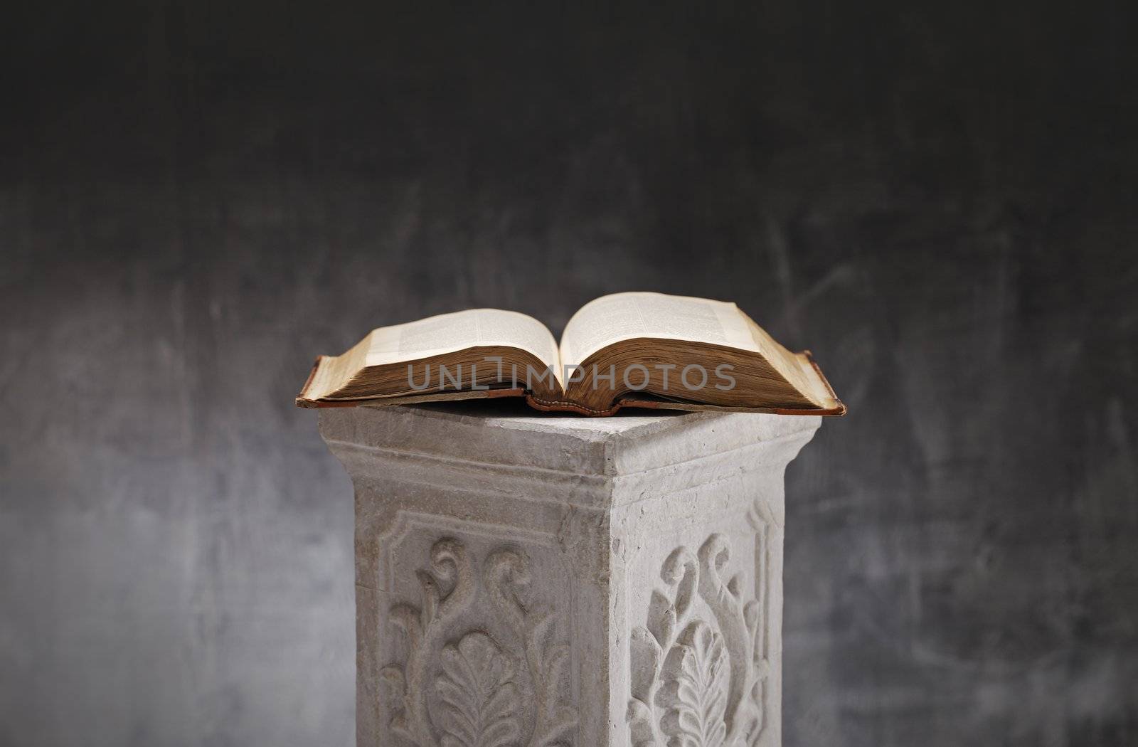 Old book opened on a plaster column.