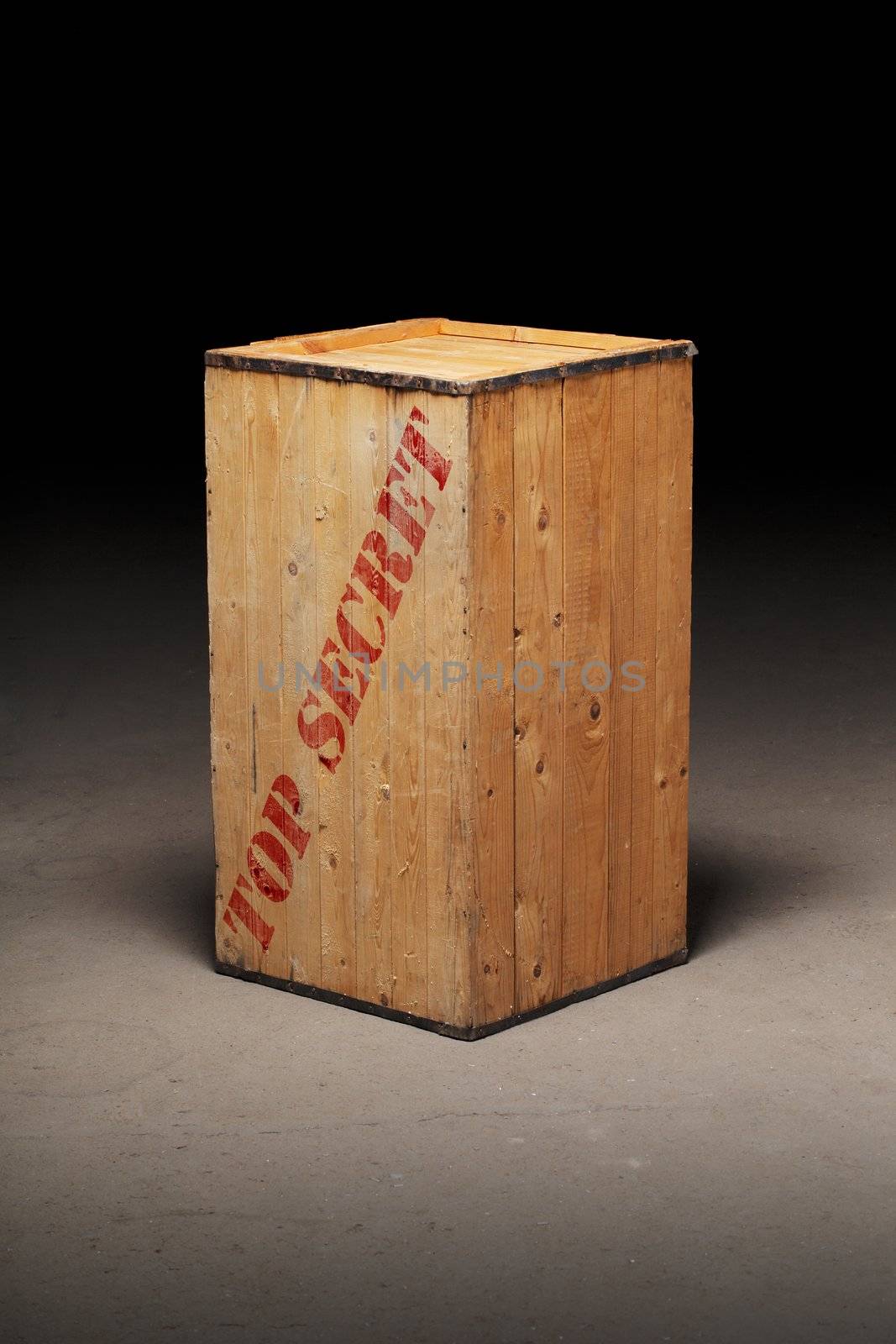 Old wooden crate with text "Top Secret" on dirty concrete floor.