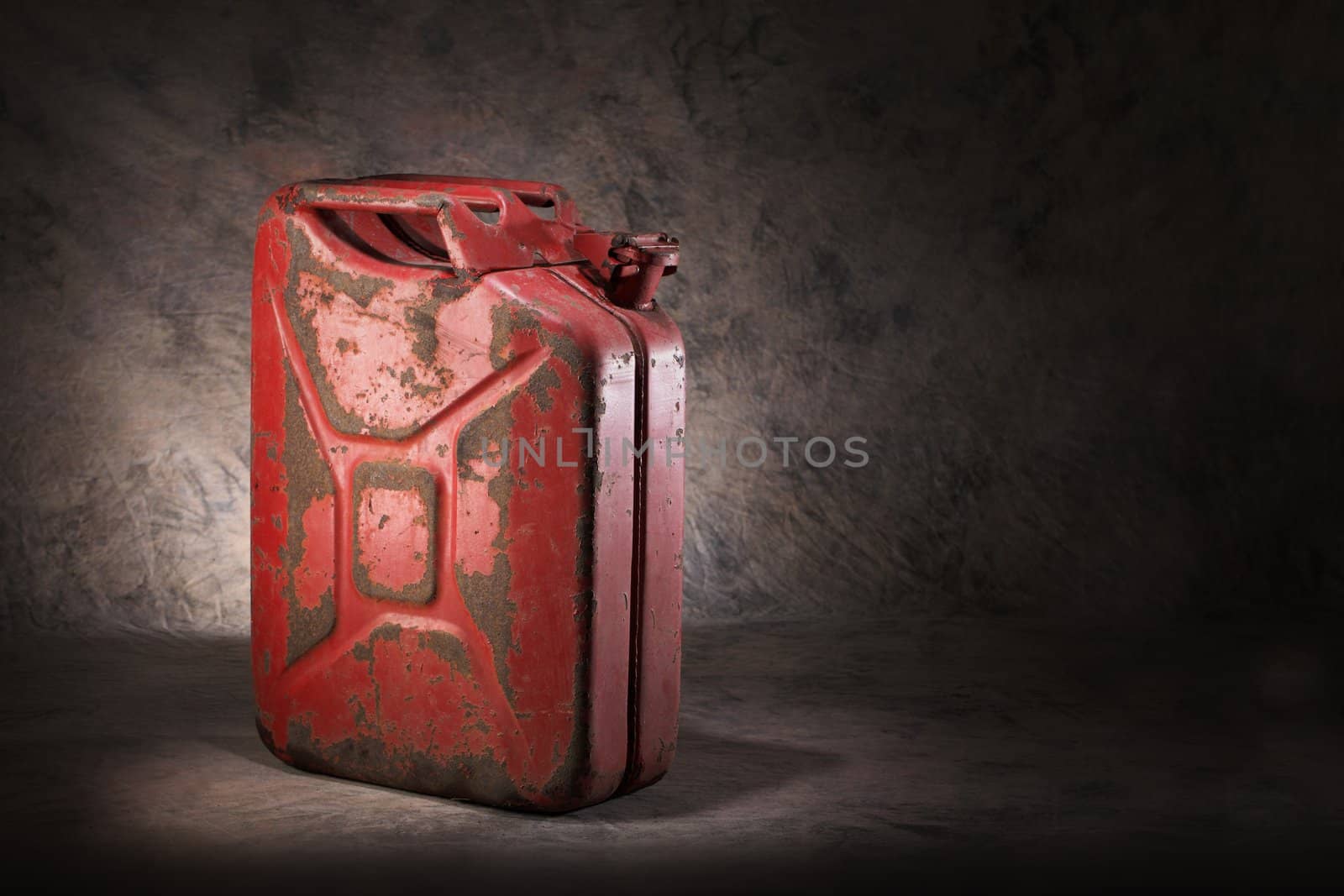 Old, dirty and rusty red jerry can fuel container.