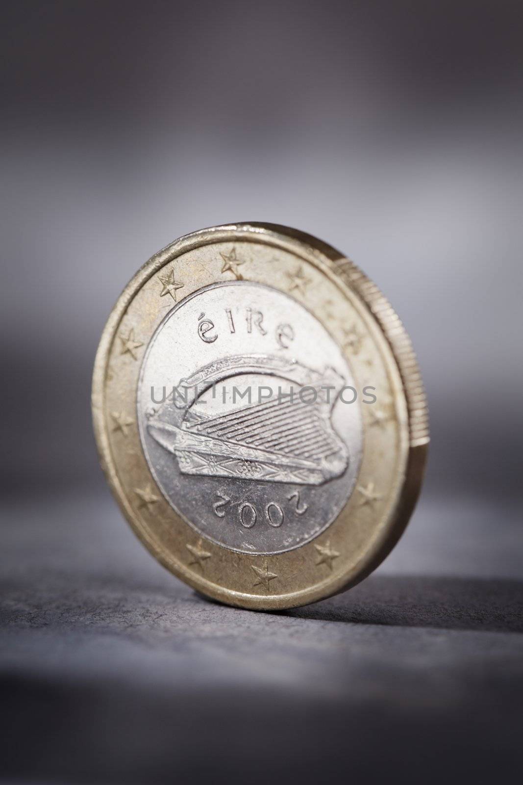 A Worn Irish Euro coin on grey. Short depth of field.