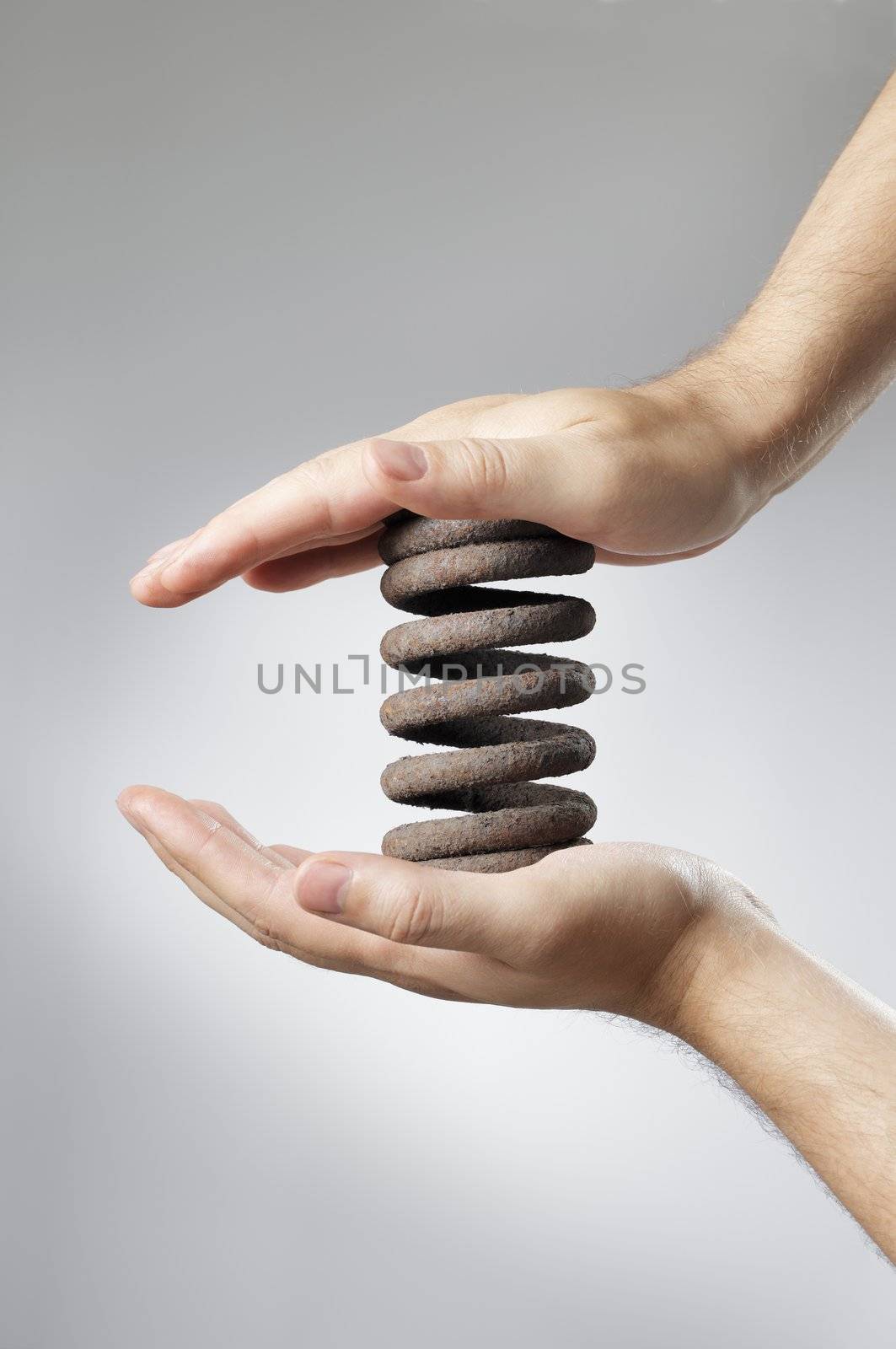 Man holding an old rusty coil spring in his hands