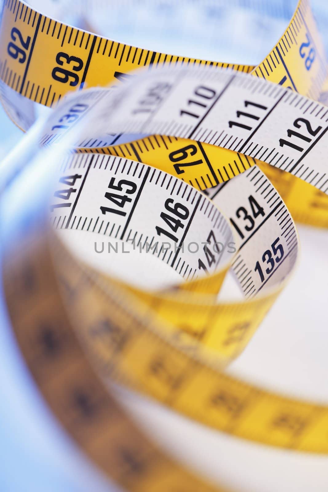 A Yellow and white metric tape measure in closeup.