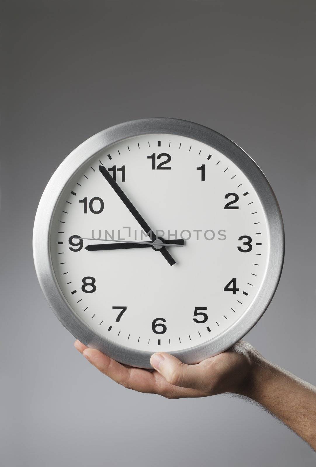 Man holding a clock in his hand.