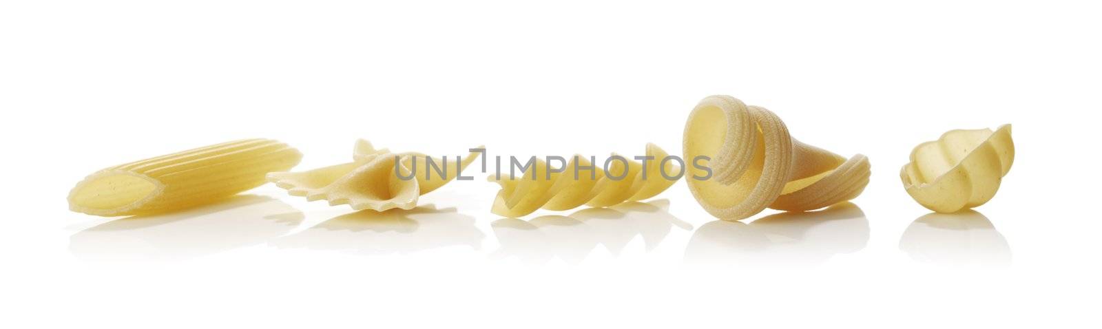 Different shapes of raw dried pasta isolated on white with reflections.