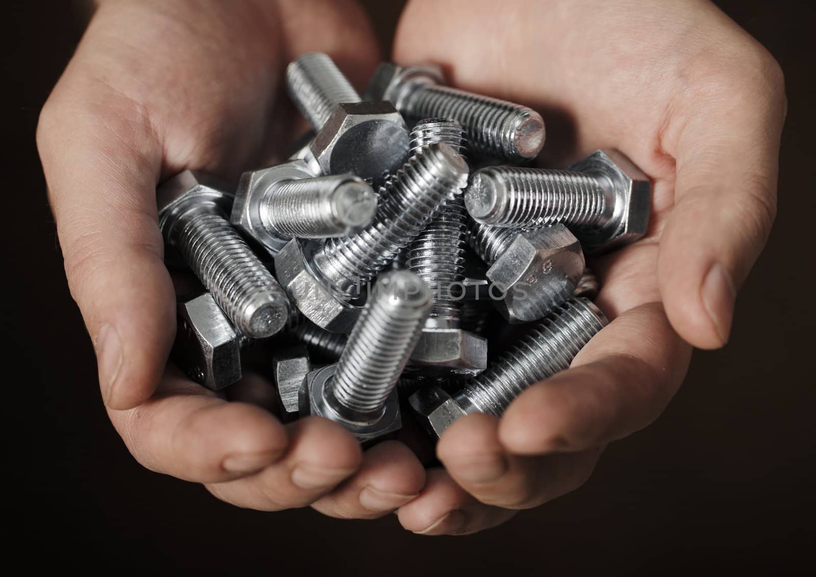 Man holding steel bolts in his hands