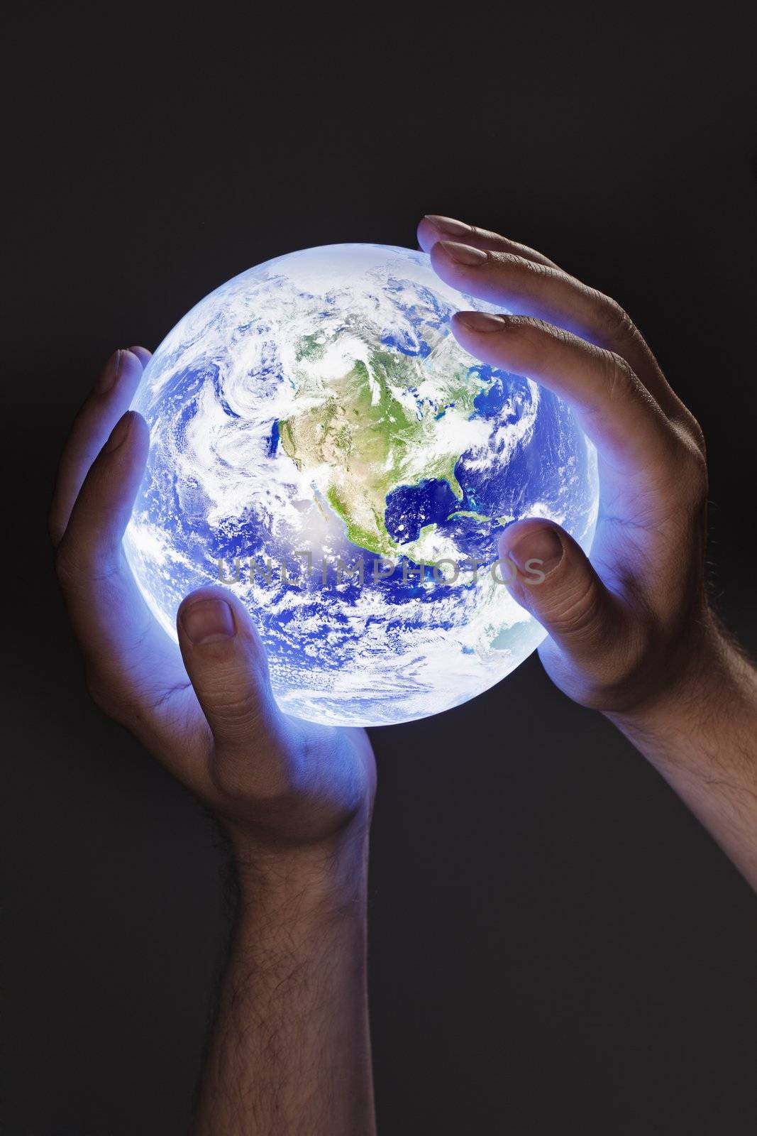 Man holding a glowing earth globe in his hands. Earth image provided by Nasa.
