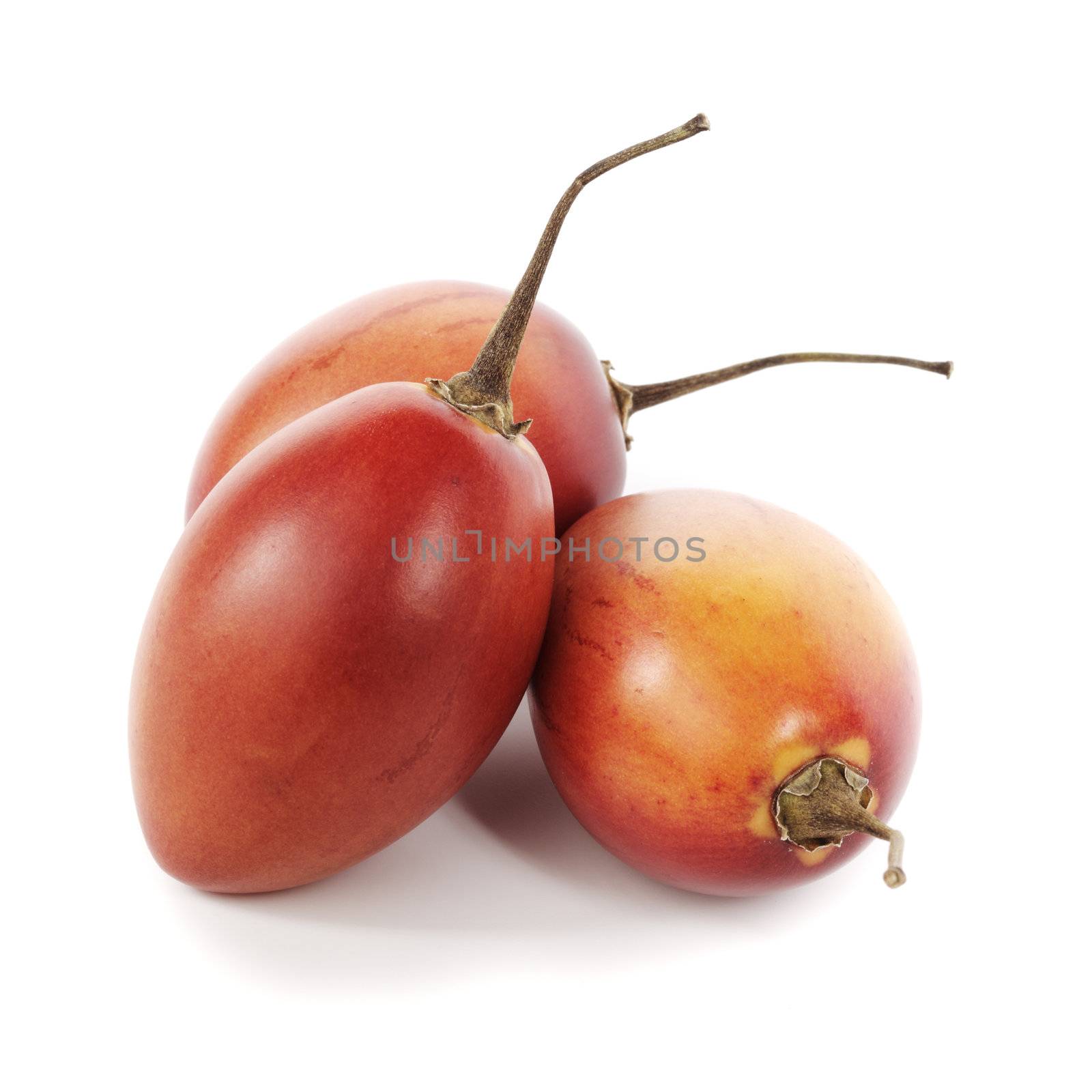 Three tamarillo fruits on white with shadow.