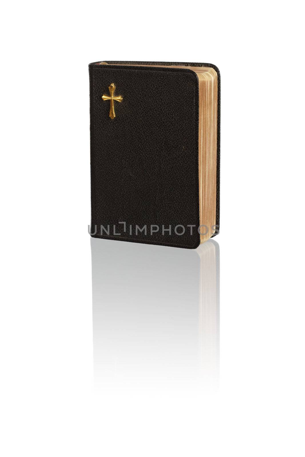 A small vintage bible on white reflecting surface