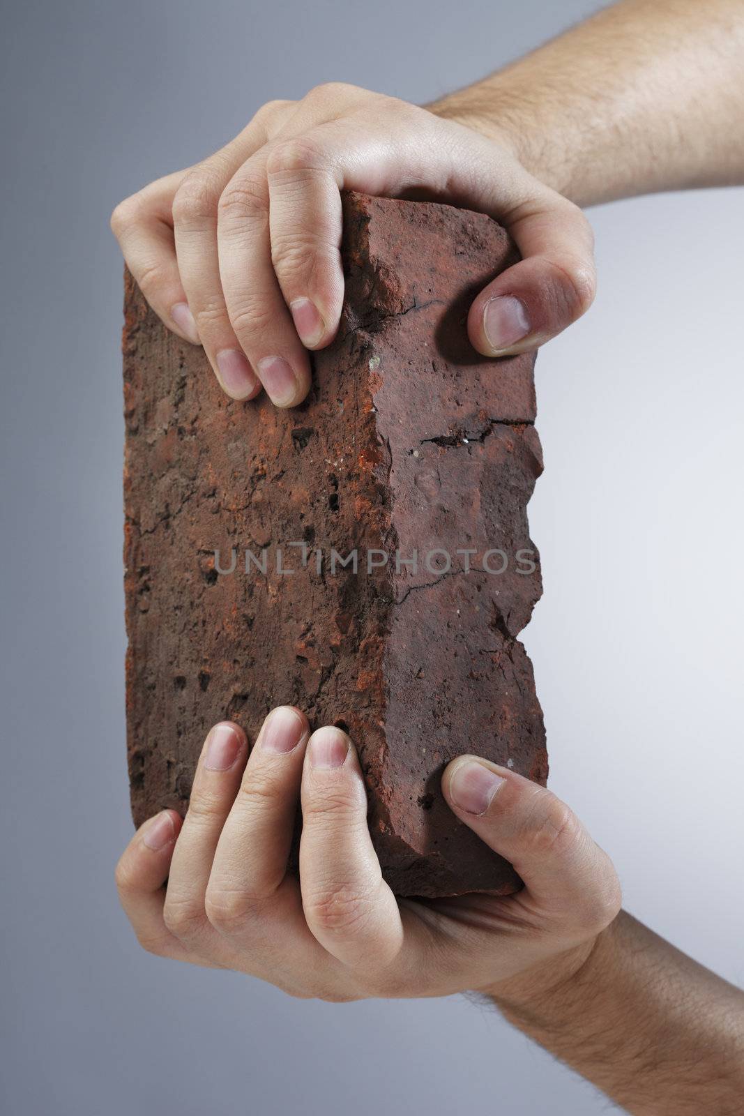 Hands holding an old brick