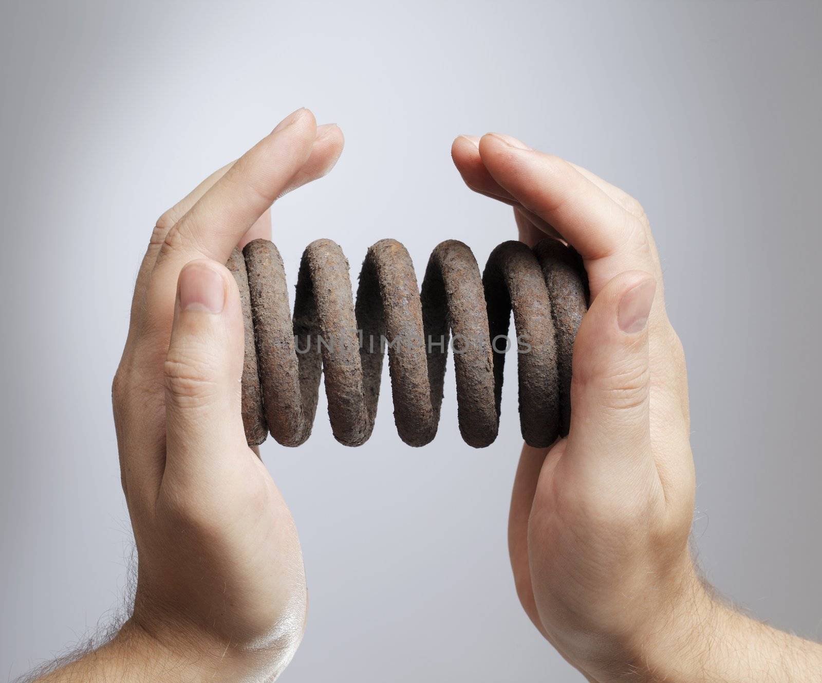 Man holding an old rusty coil spring in his hands