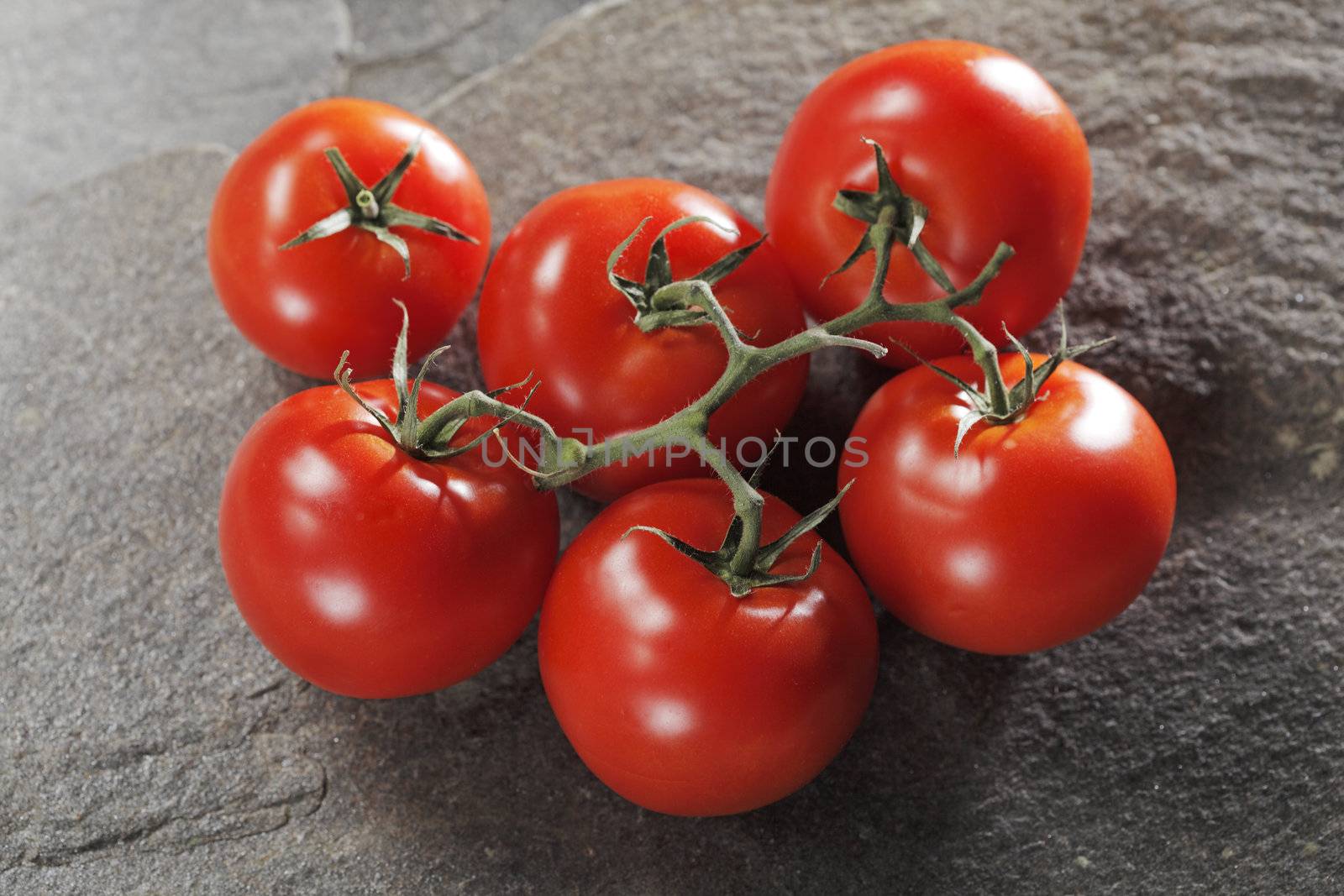 Red ripe tomatoes on stone background