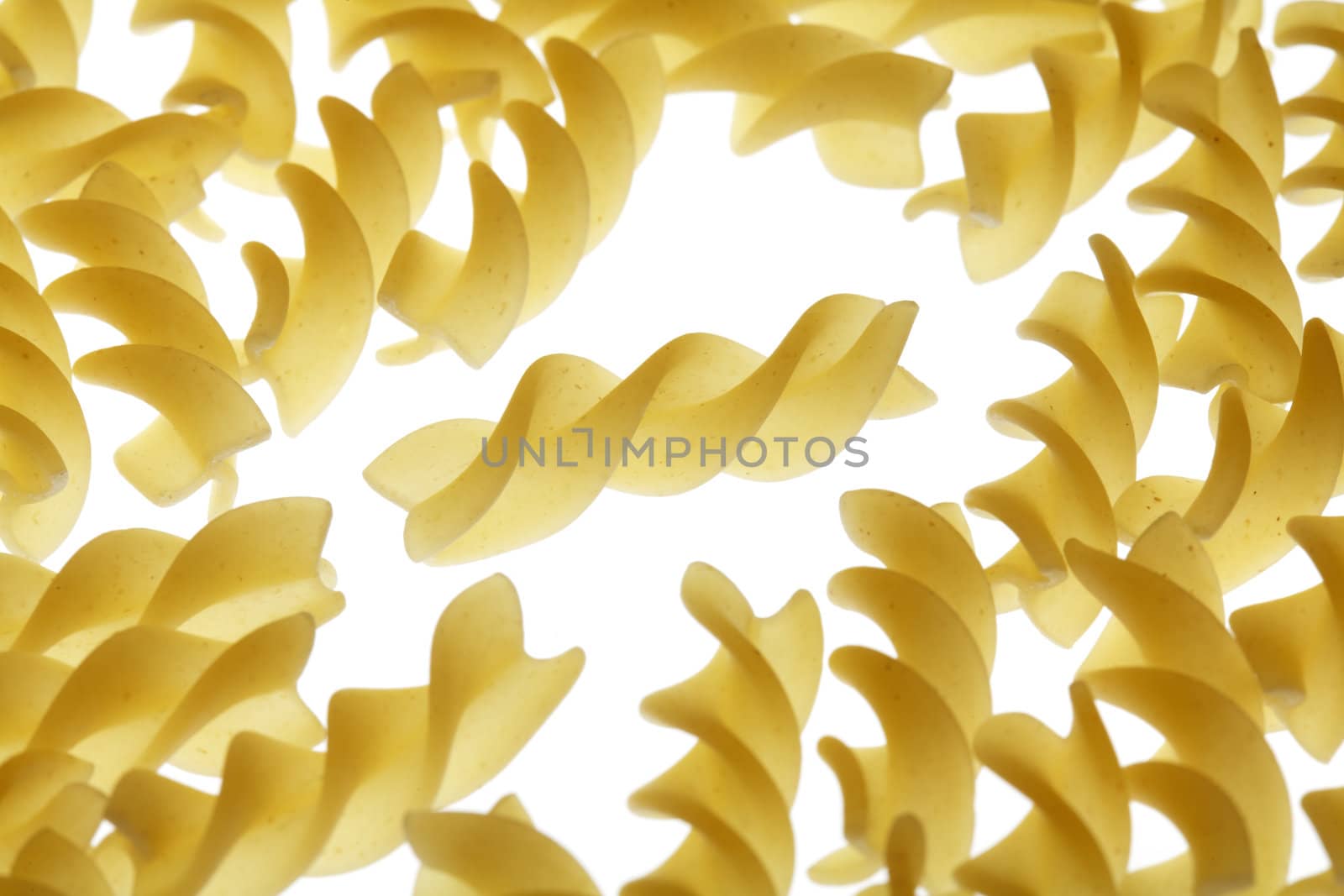 Uncooked pasta fusilli on white background