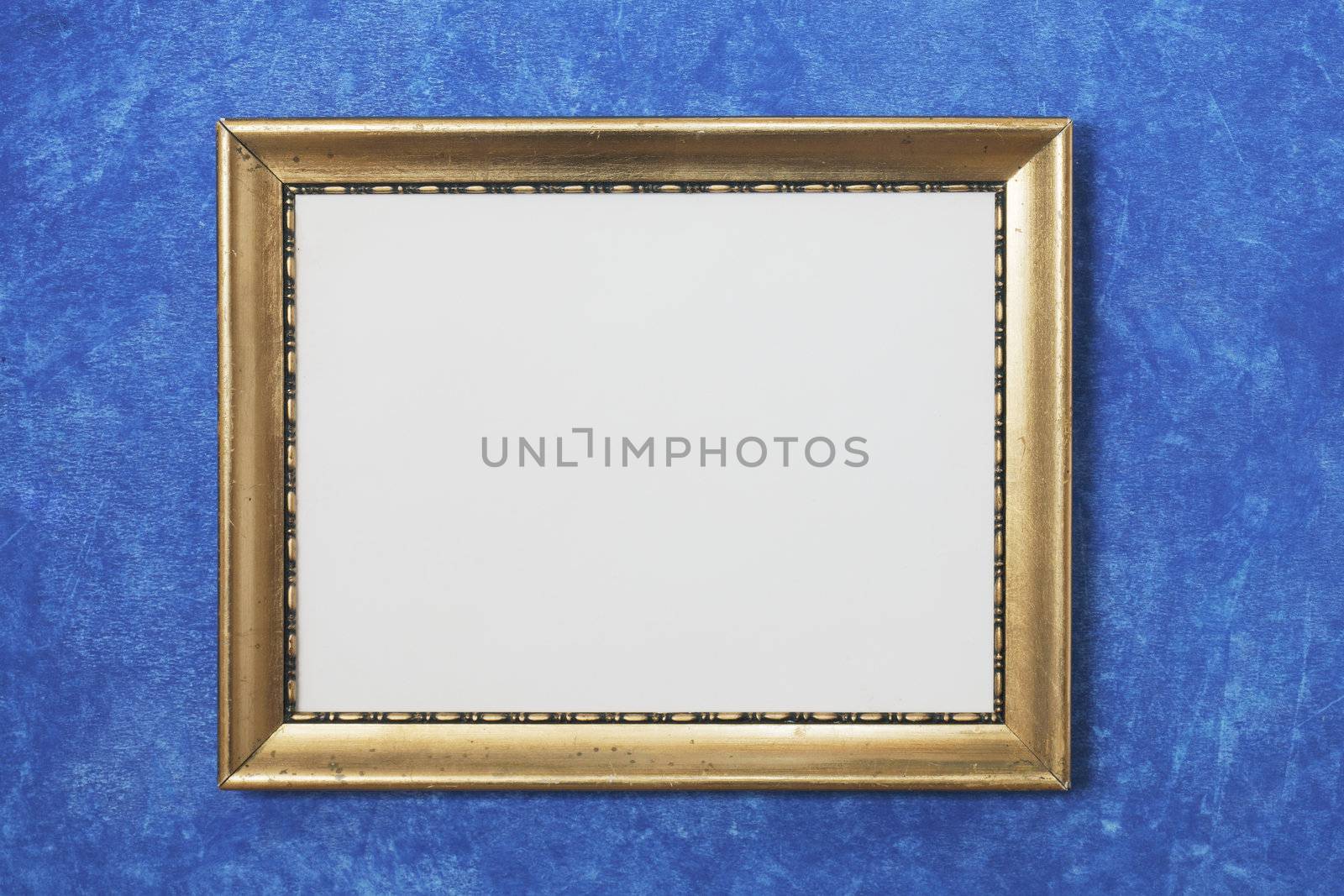 Old golden colored frame on blue