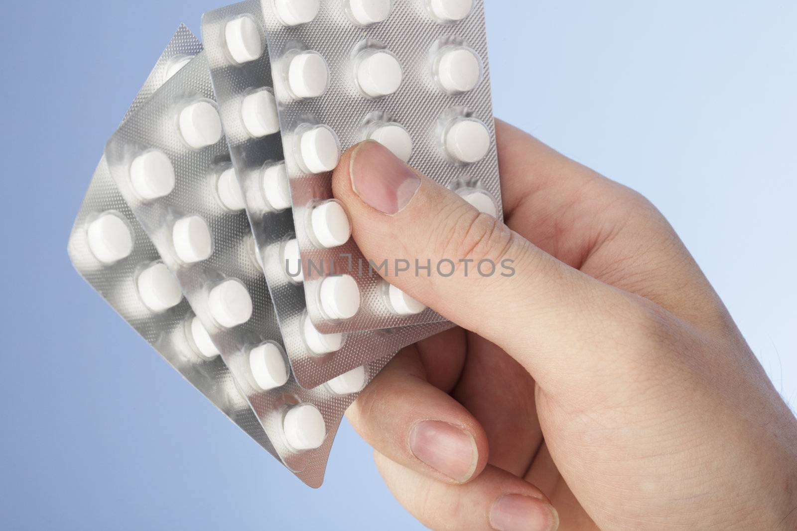 Hand holding pills in blister packs