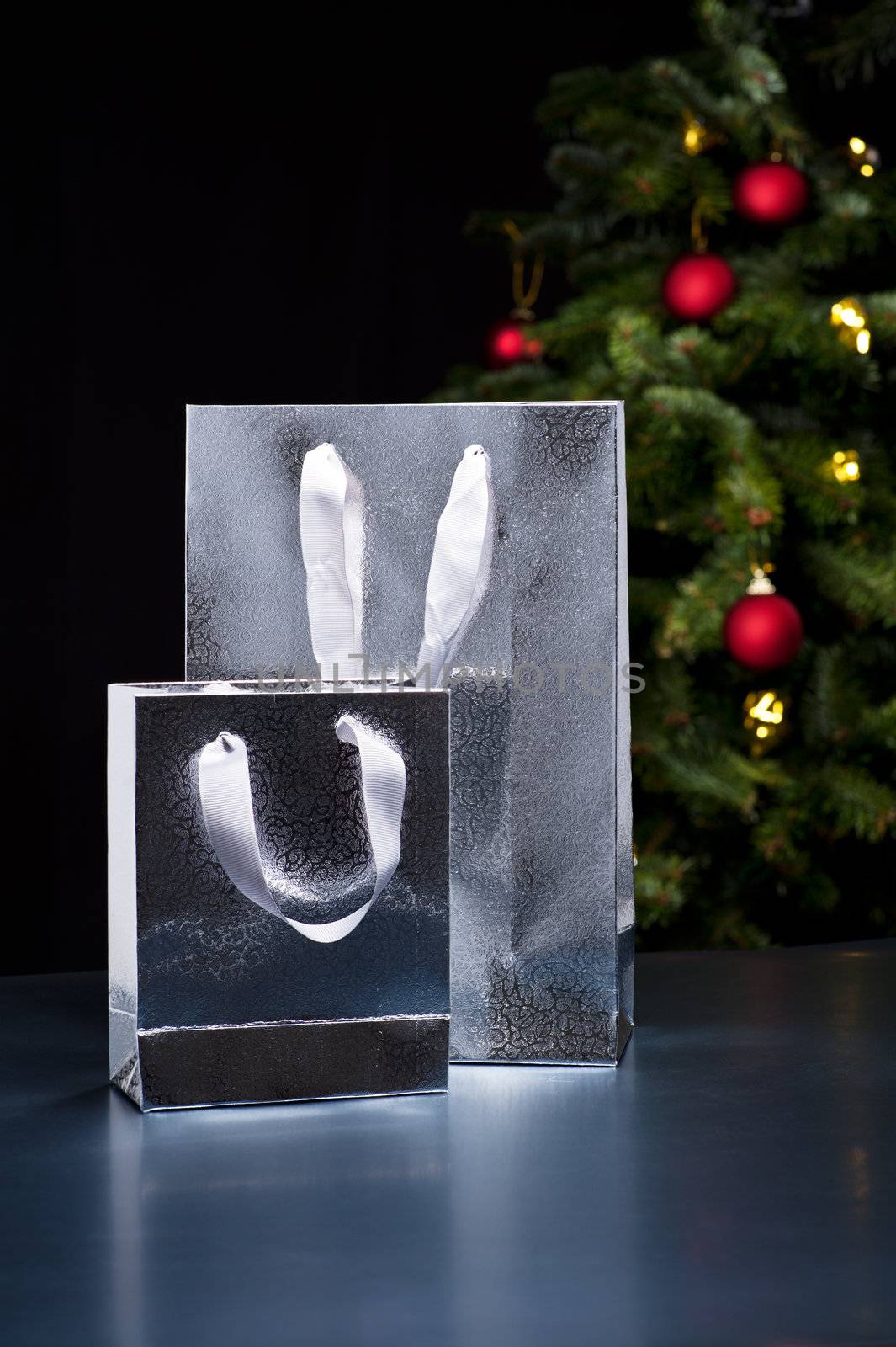 Two silver shopping bags in an elegant Christmas setting