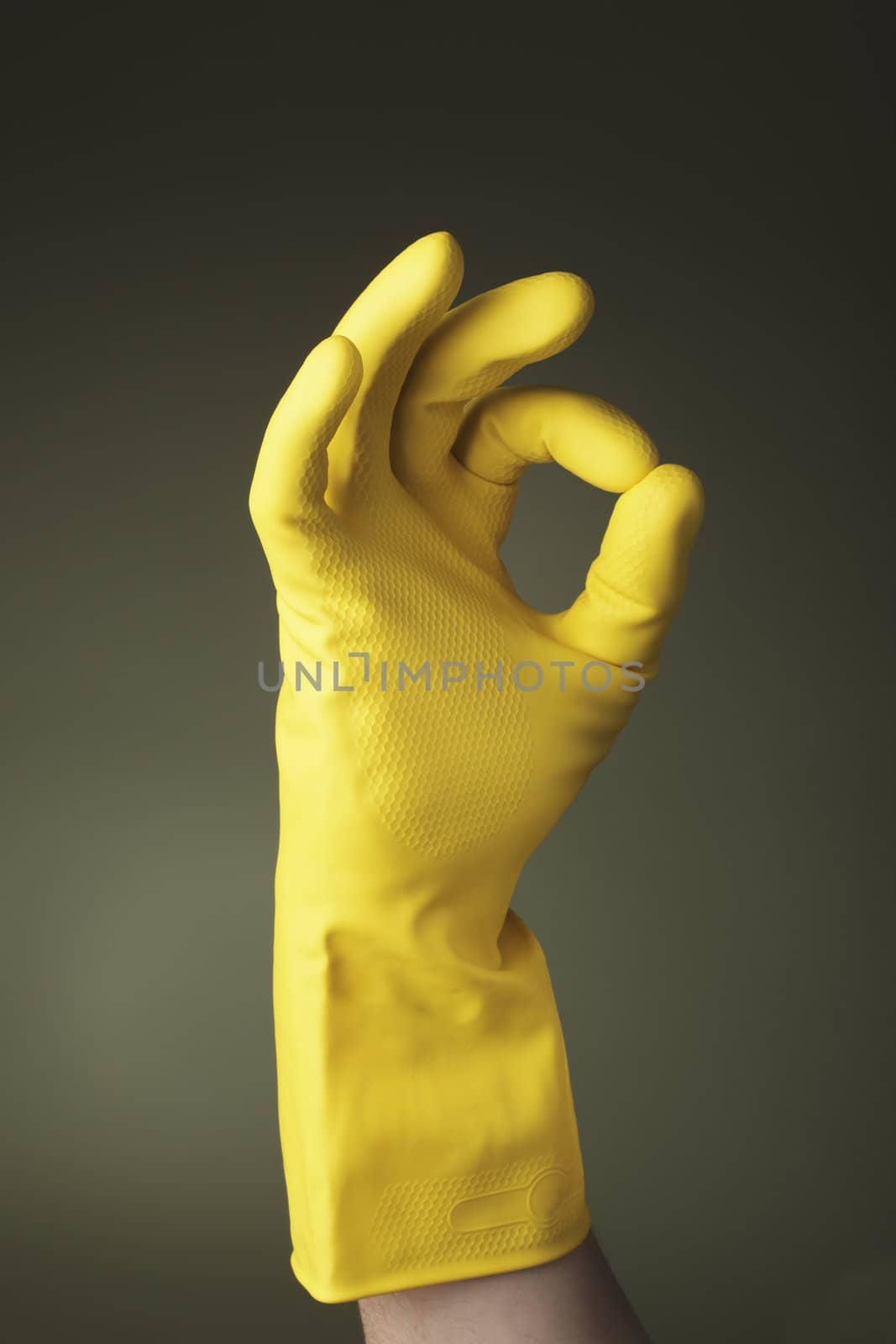 A hand wearing a protective glove doing "ok" sign