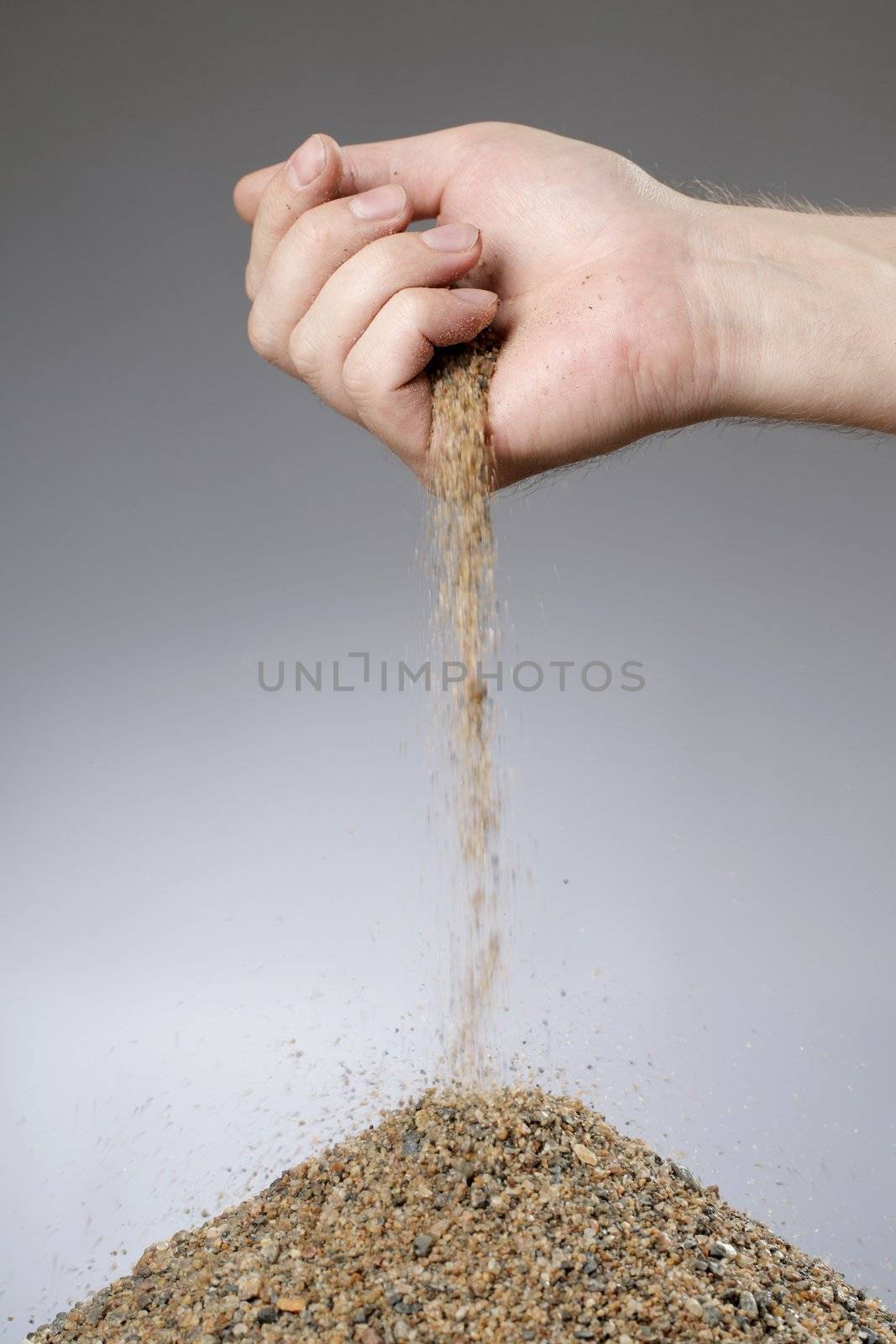 Man adding sand in a heap with his hand