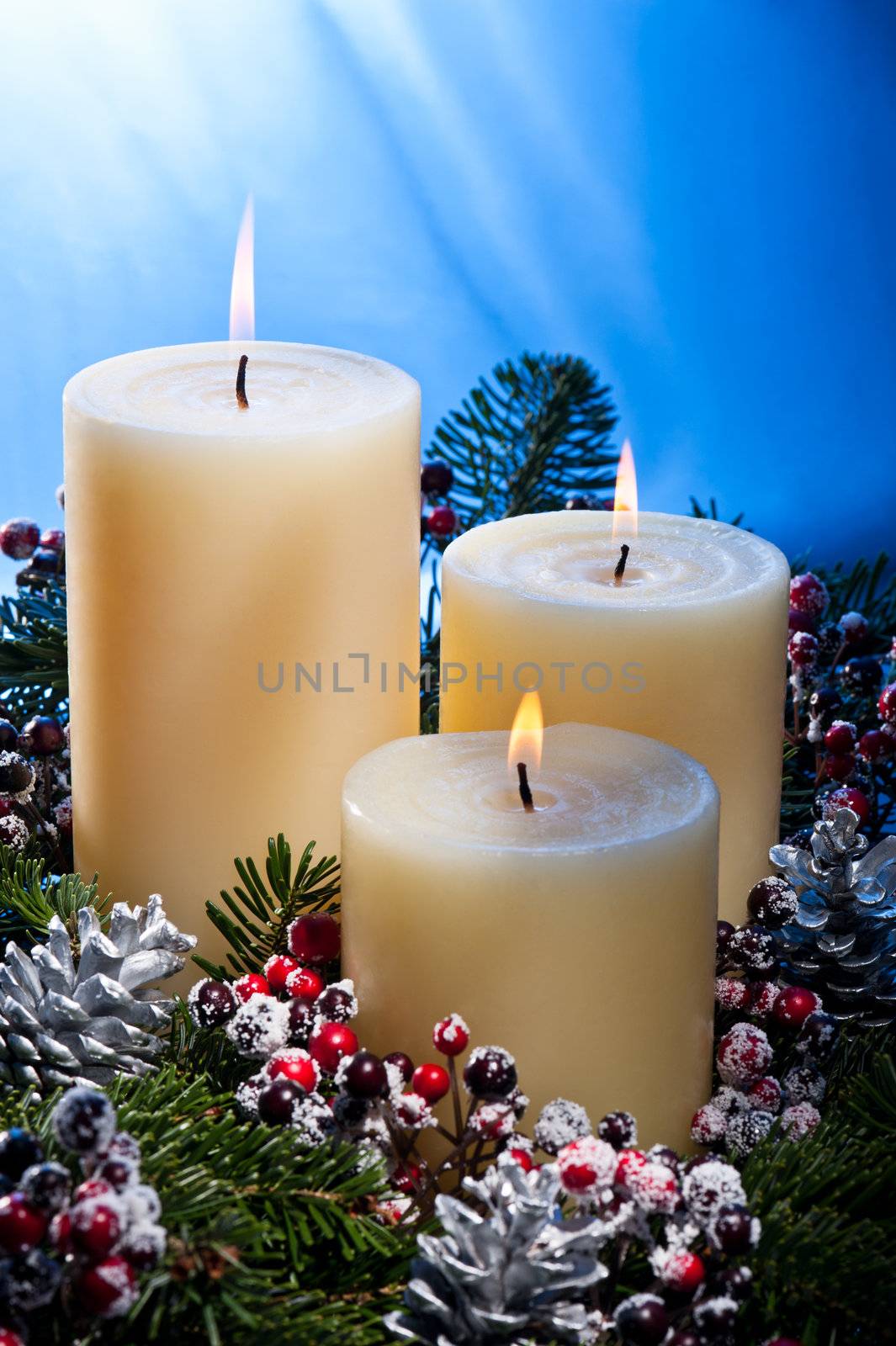 Three candles in an advent flower arrangement for advent and Christmas