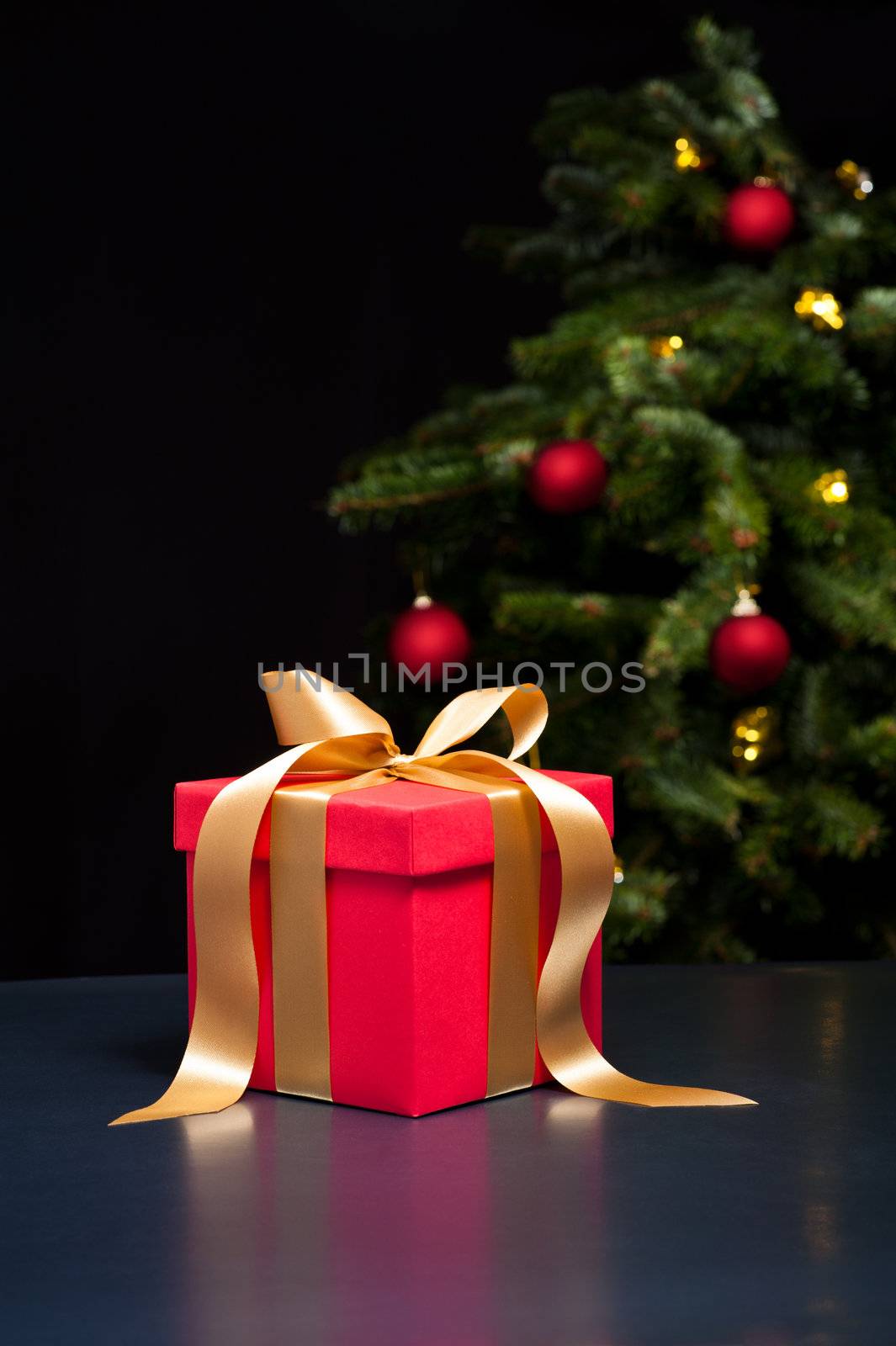One present with gold ribbon in an elegant Christmas setting