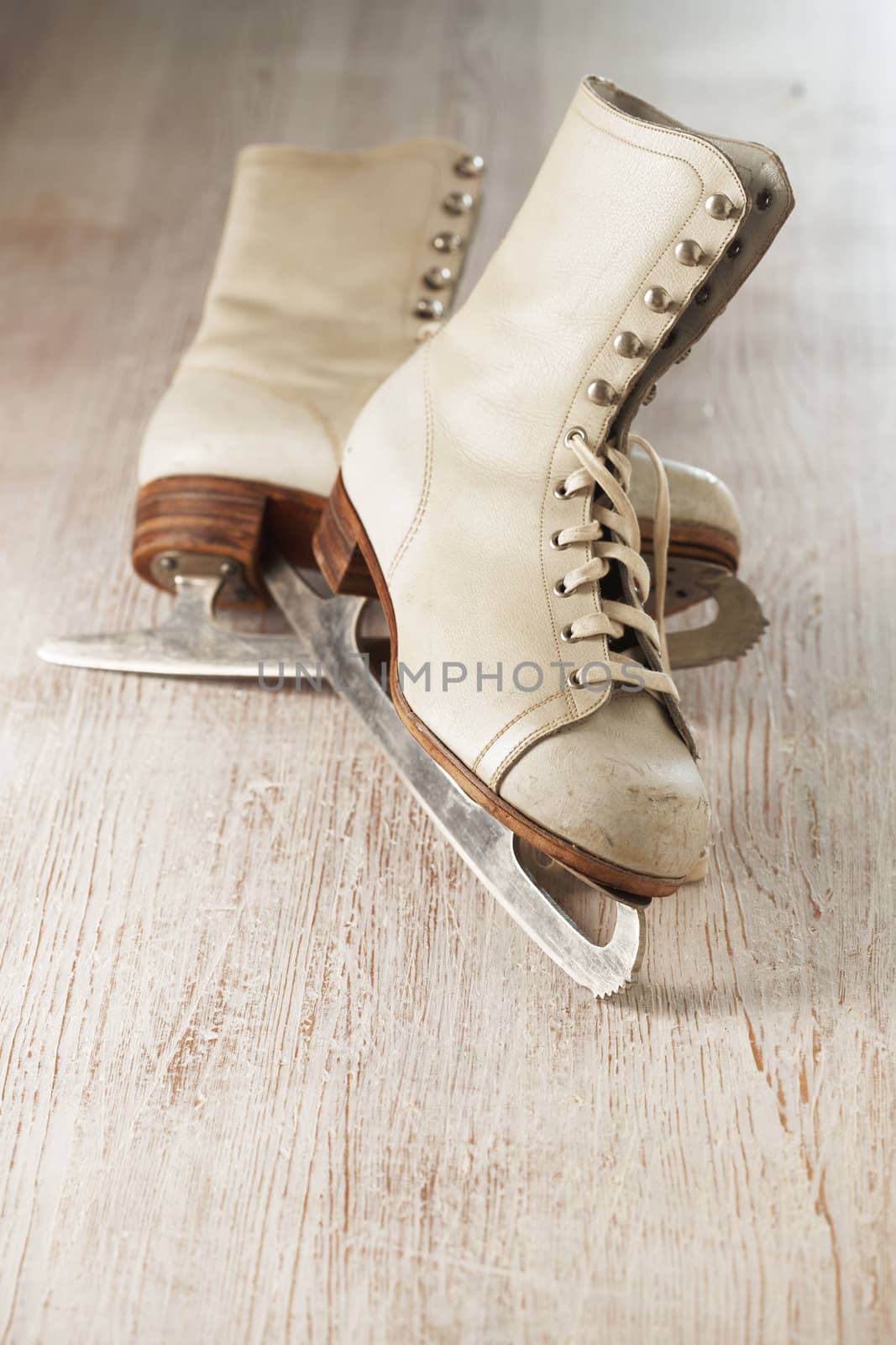 Old white women's ice skates on wood