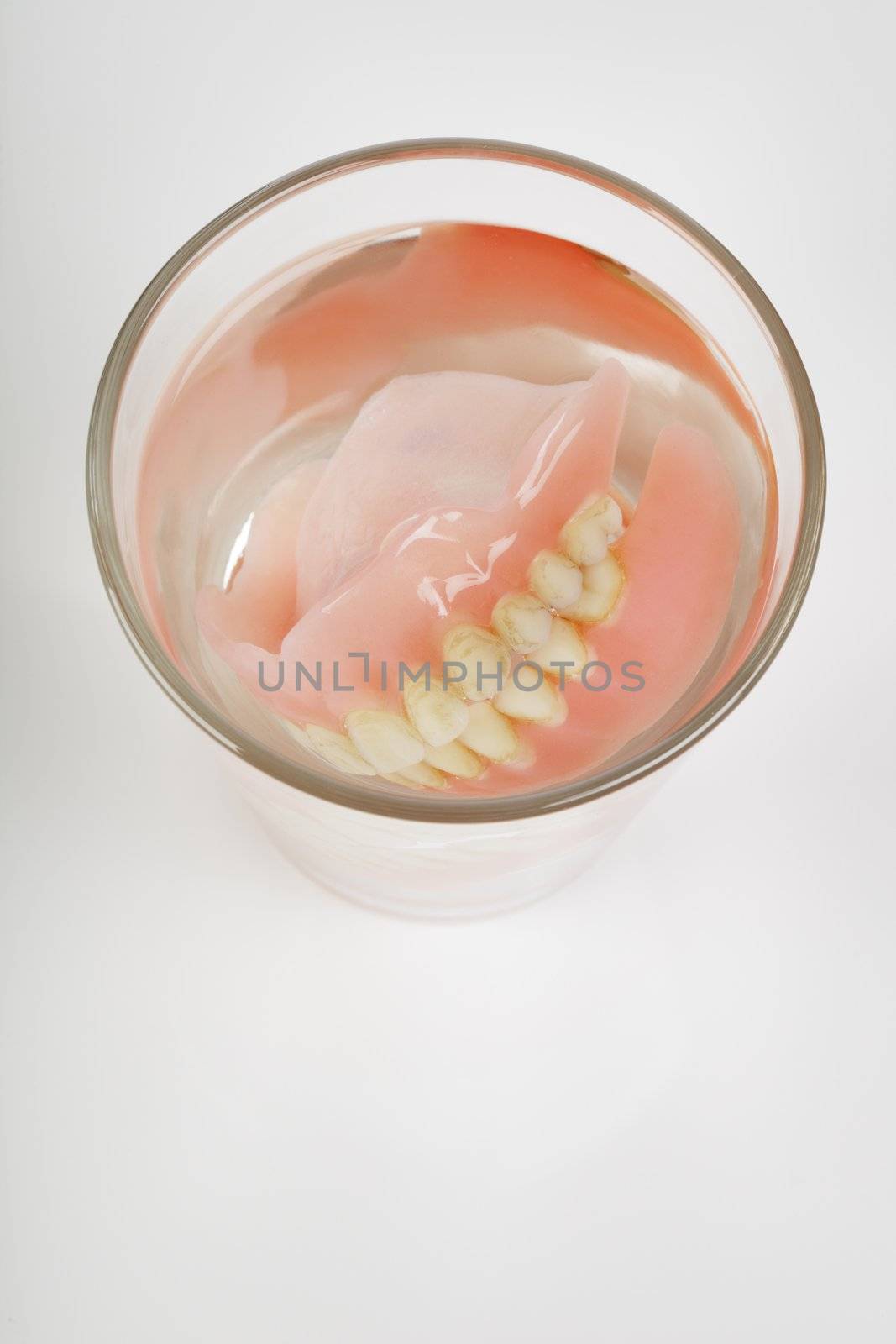 Old dentures in a glass of water