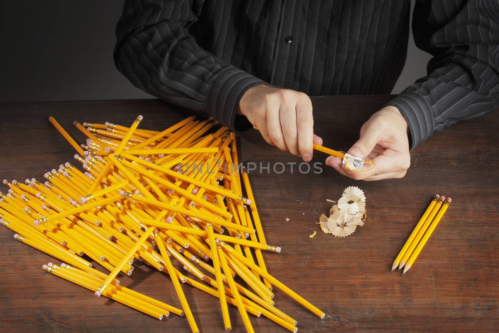 Man sharpening pencils with a pencil sharpener