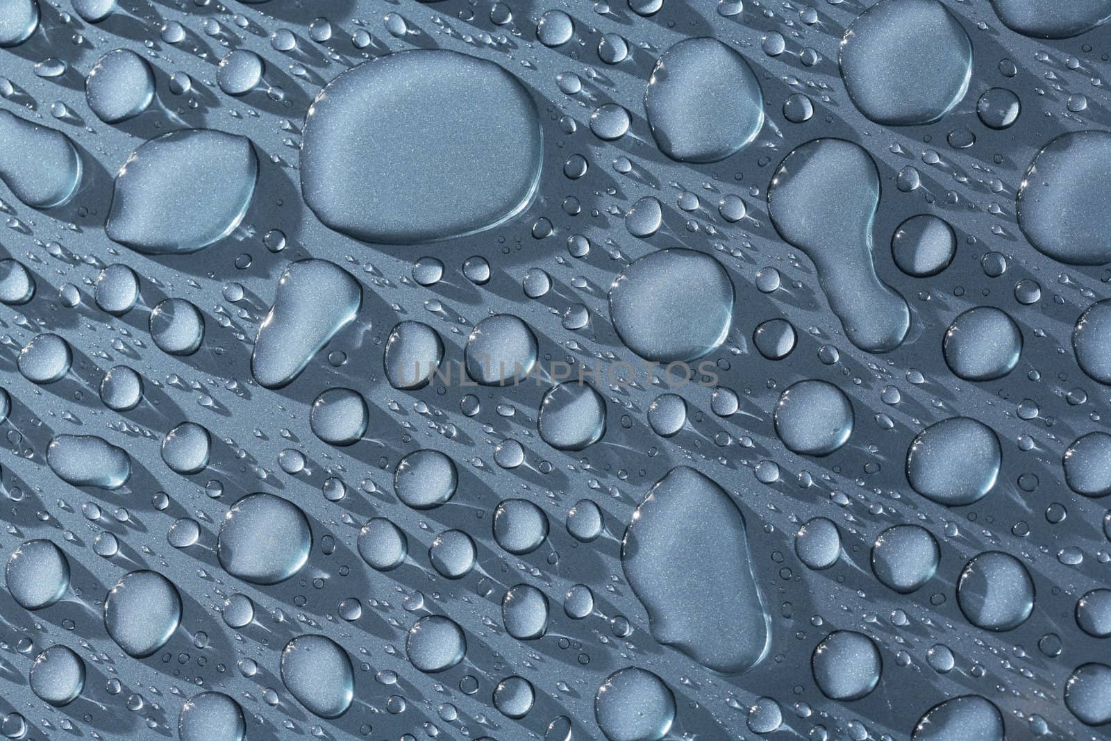 Water beads on a metallic blue car. The image may appear noisy, but it's just the metallic paint.