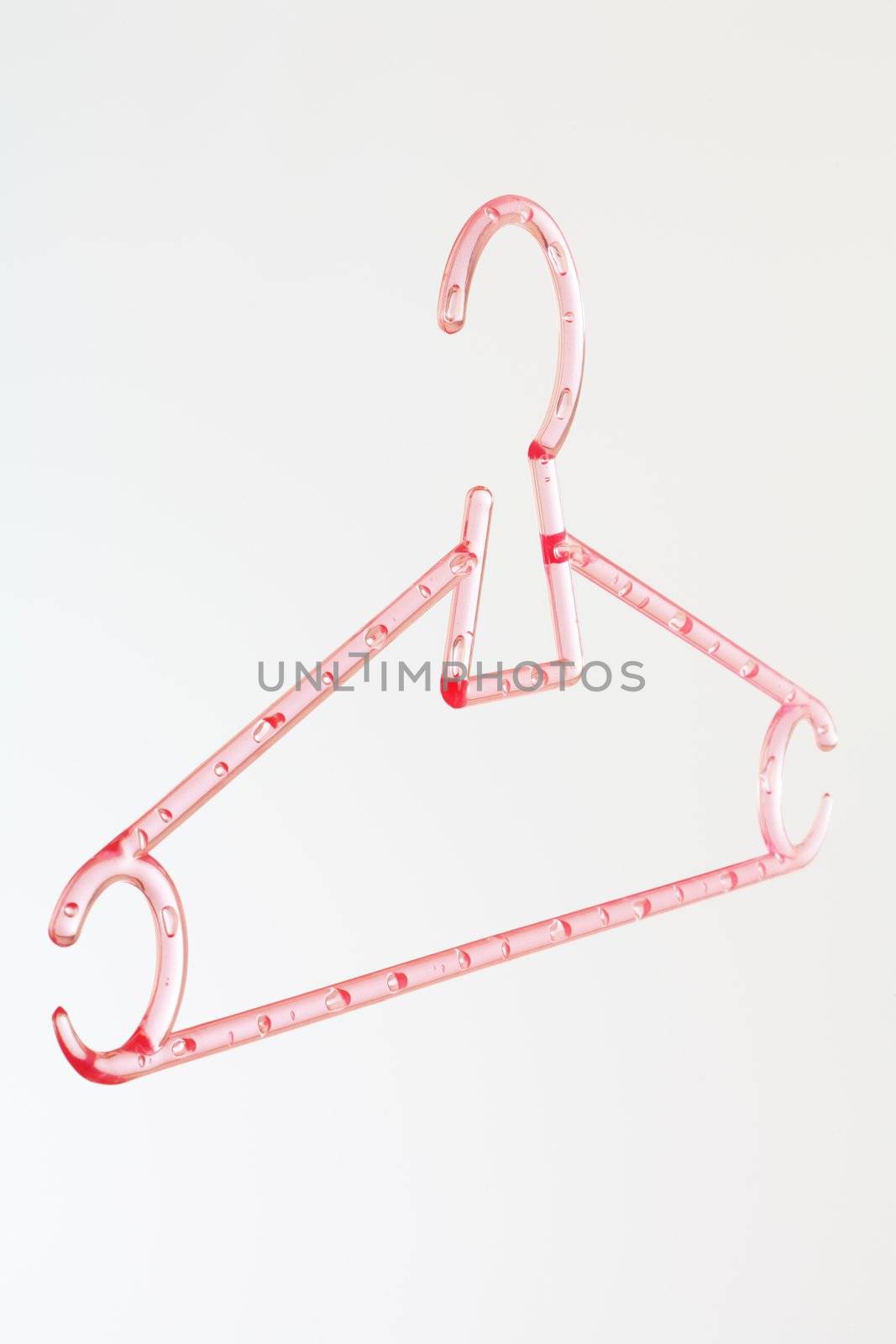 Pink plastic hanger on light grey background