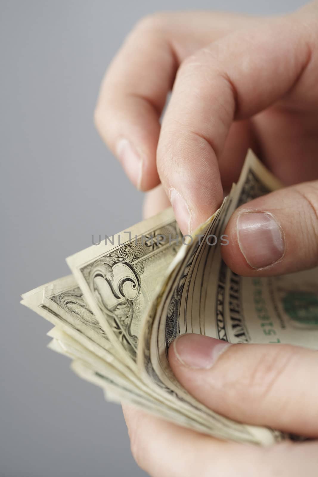 Counting old dollar bills with fingers. Short depth of field.