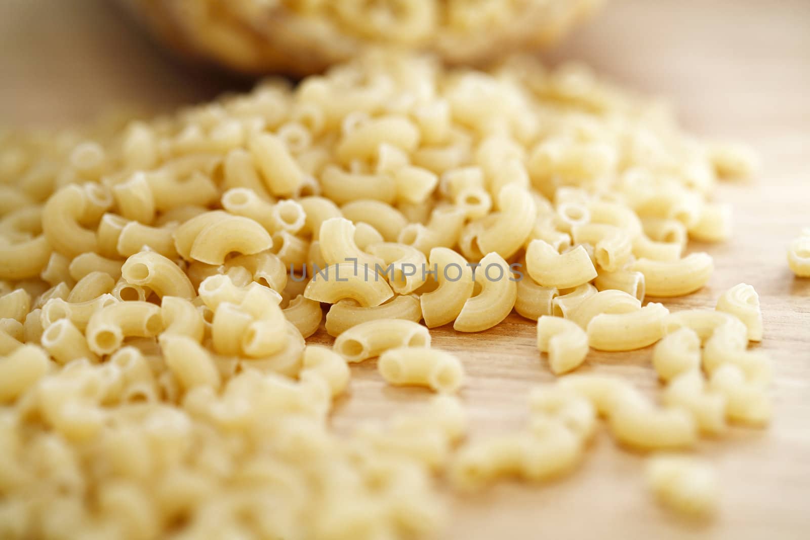 Macaroni pasta heap on a wooden table