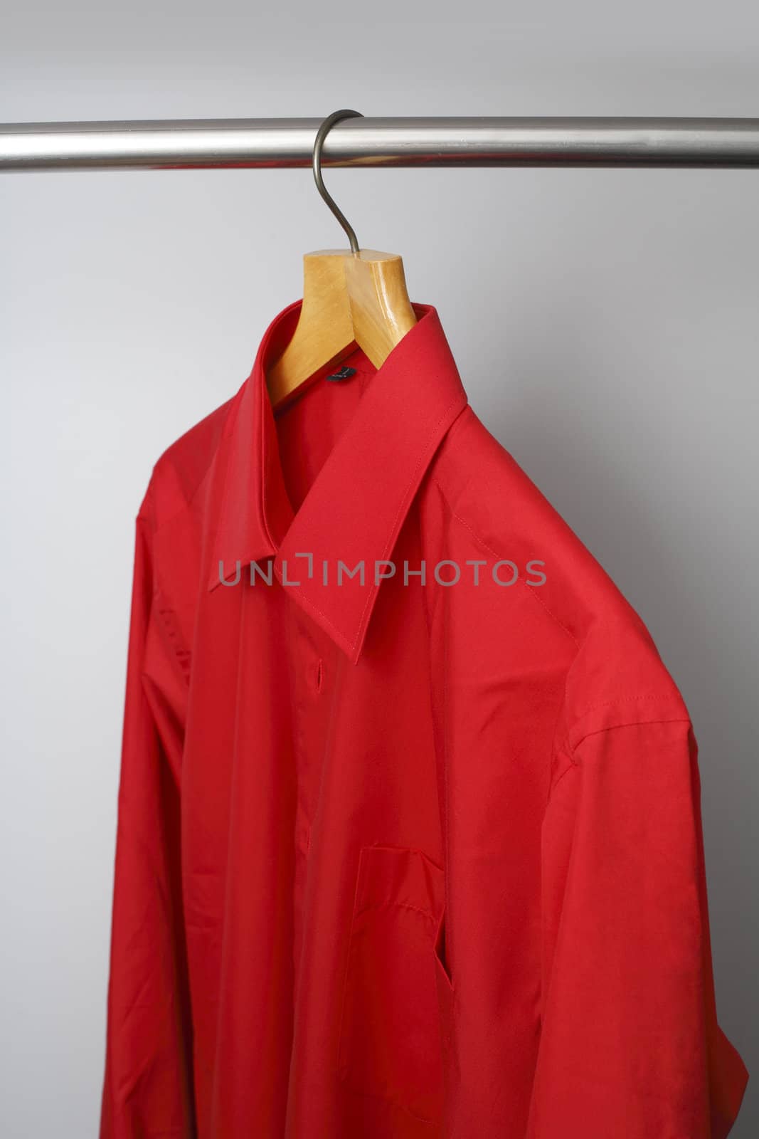 Red shirt hanging in wardrobe.